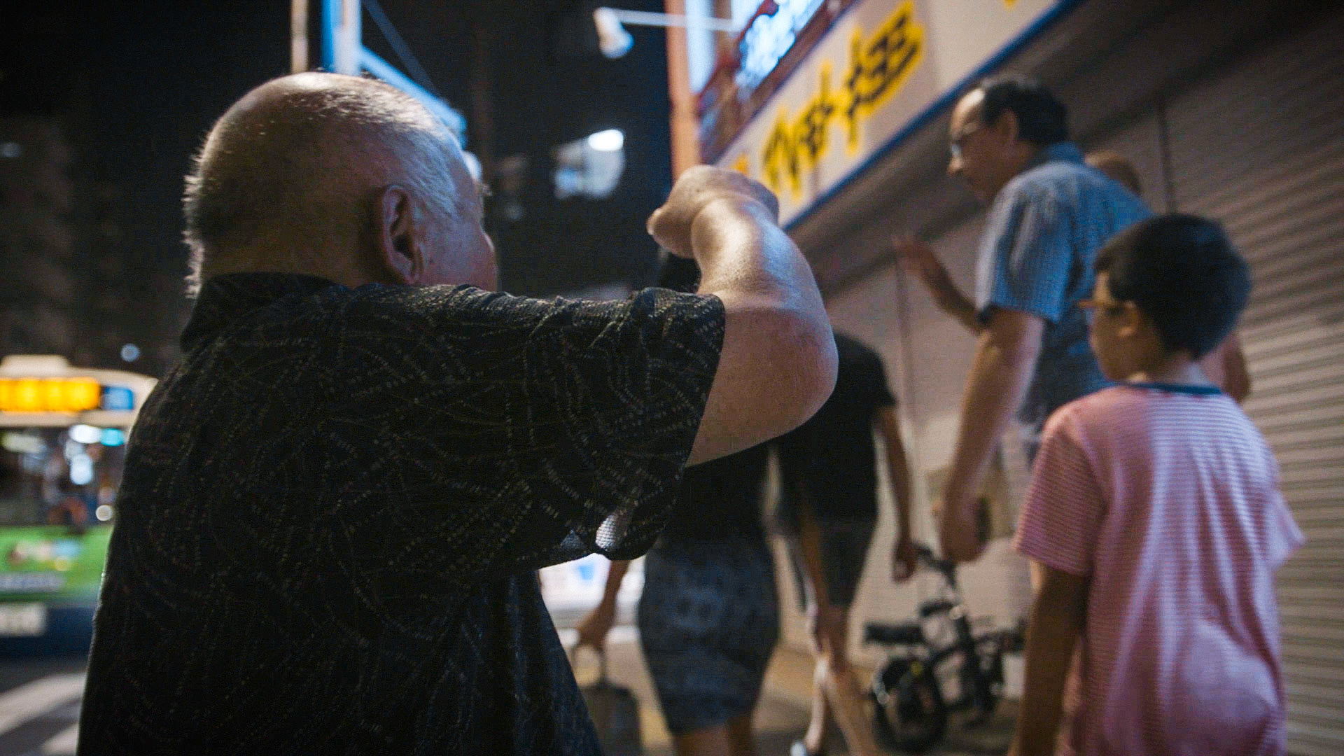 Harmonica 7 | Ishino at a bus stop, repeatedlly passed up the bus-rides, and tried to start a conversation with foreign tourists walking on the side of the road by just saying "hello!" that only English word he knows, 29 July 2019.