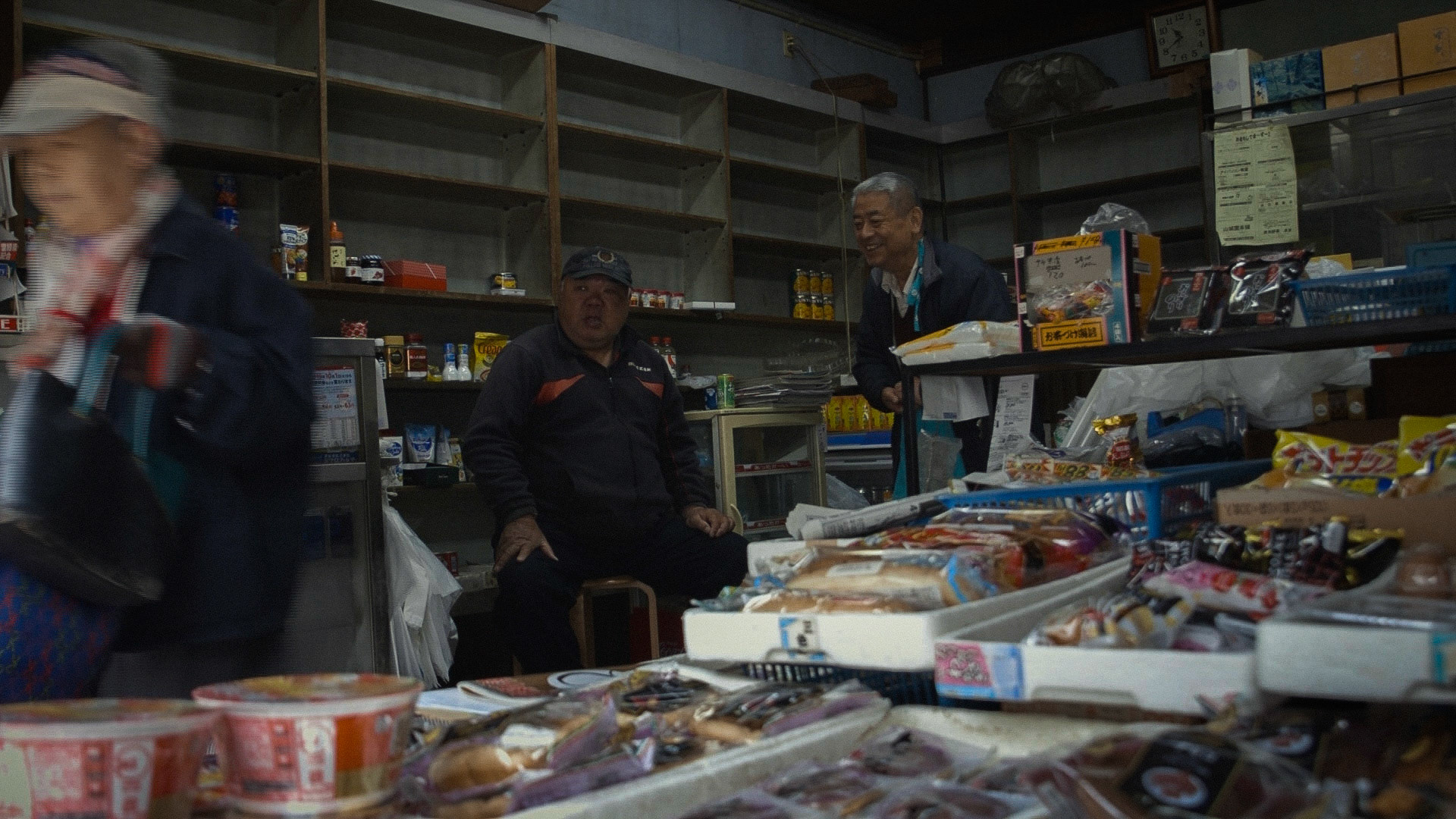 Harmonica 10 | Omi-ya, the shutter being closed halfway and selling limited items roughly arranged, is a local store in Sanya district where the owner has greeted and helped customers like Ishino by accepting a deffered payment and receiving a package for homeless people since 1922, 10 April 2020.
