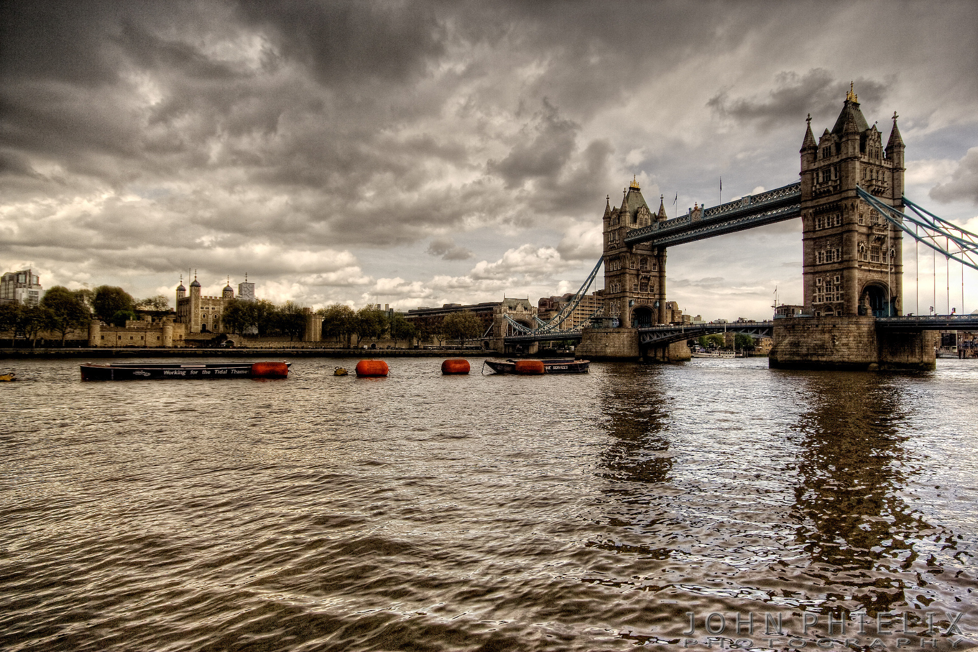 Tower Bridge crossing the River Thames in London, England, with the historic Tower of London visible on the north bank in the background