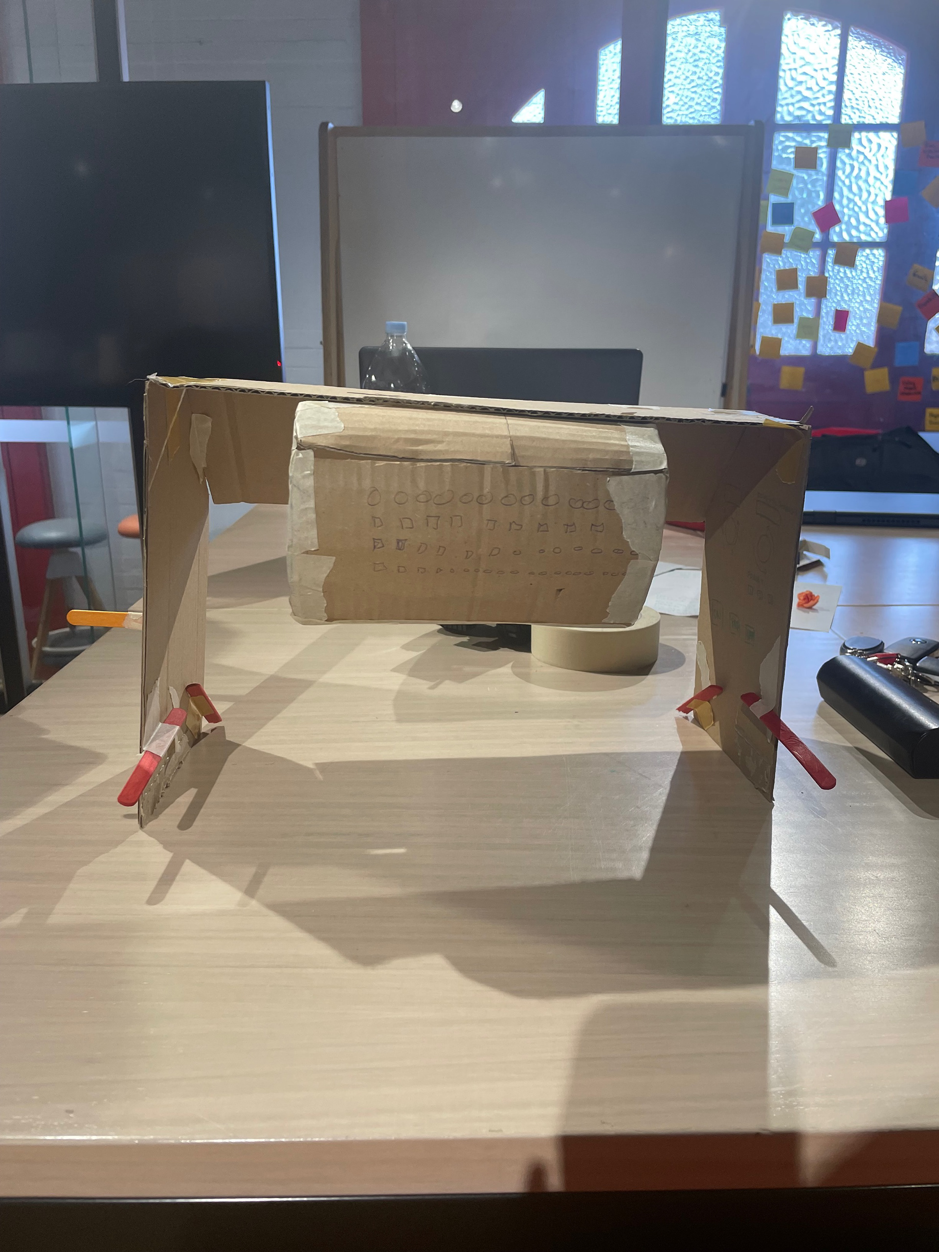Universal Design in the Kitchen, Domestic Dough Sheeter Prototype. Created with cardboard, masking tape, popsticks and paper. Back view.