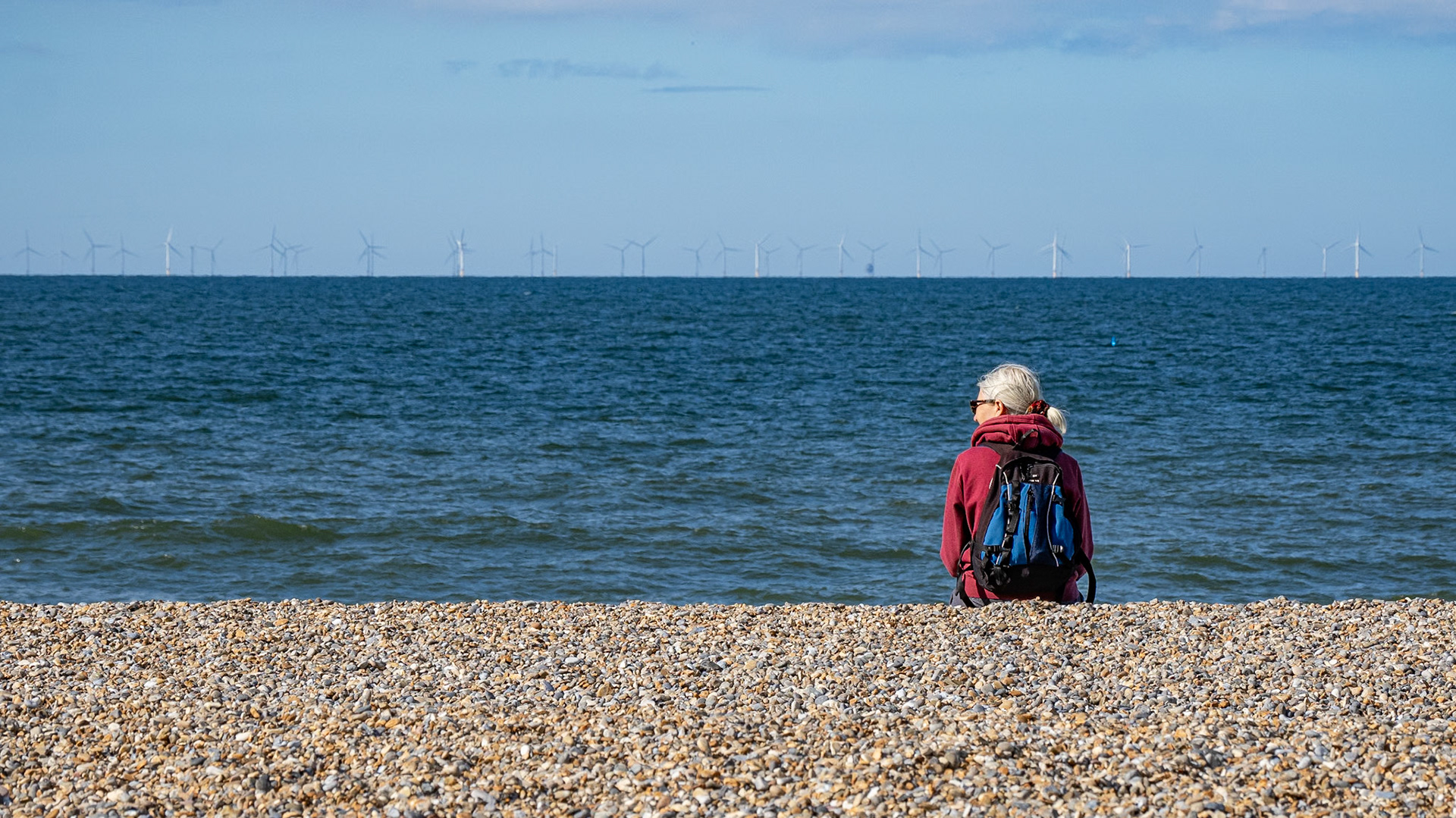 Annie sitting on the beach at Salthouse, Norfolk, July 2020