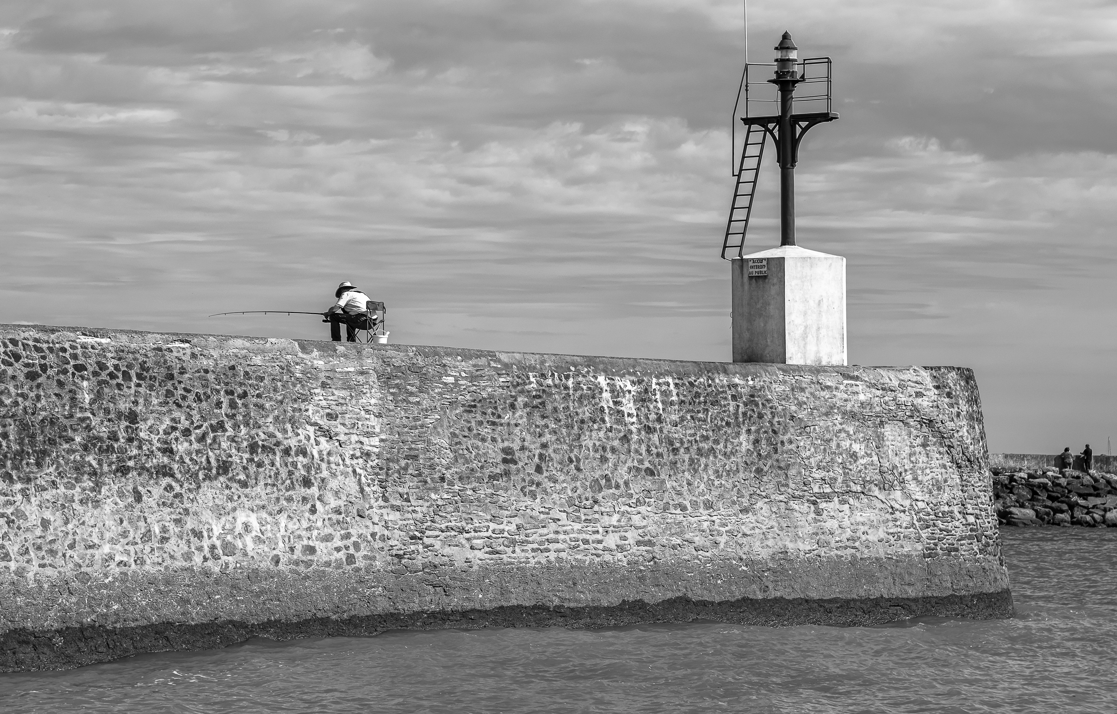 Un pêcheur sur la digue du chenal de Boisvinet, Saint Gilles Croix de Vie, photo noir et blanc 34