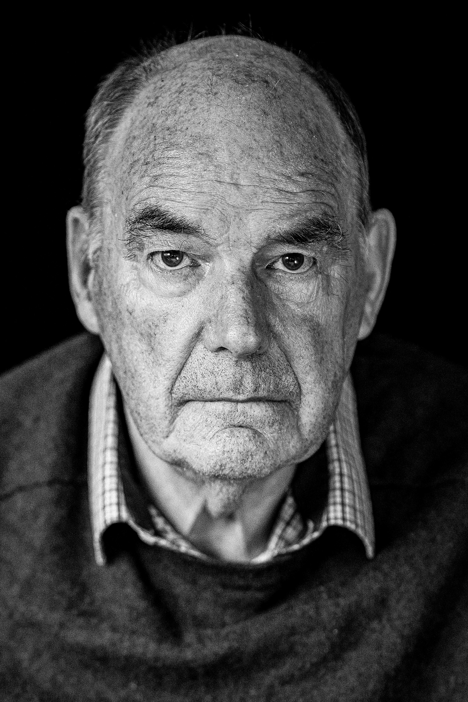 zwart wit portretfoto van oudere man gemaakt met mobiele fotostudio bij hem thuis.