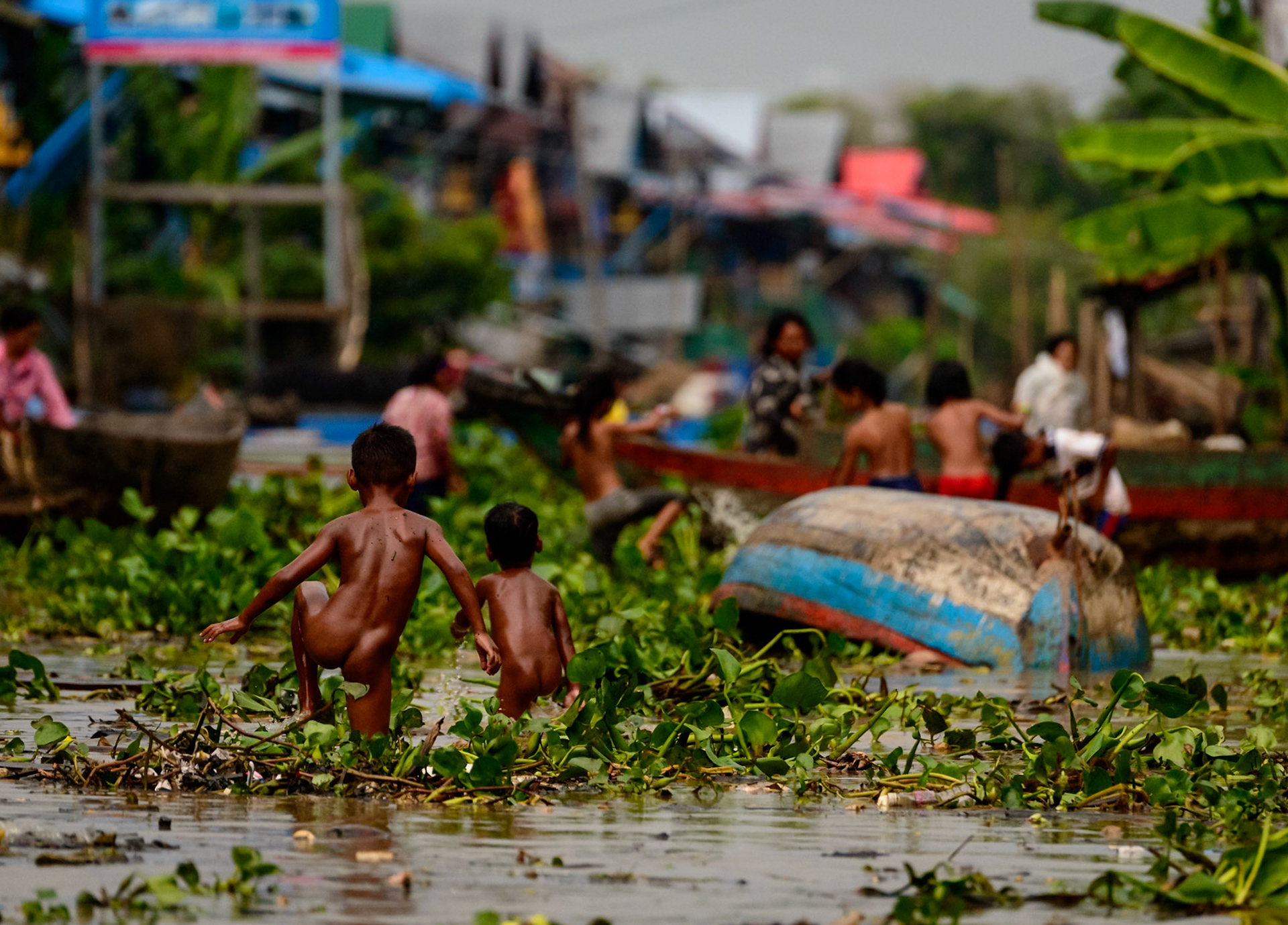 The skies had blackened before dumping a deluge of rain. I stood on the edge of the street of this floating village - watching the water rise at my feet. As the water rose, the coolness of the storm brought out the villagers from their homes. In minutes, the lagoon turned into a playground of activity. Two young brothers played in the water, racing each other across the street, their birthday suits seeming perfectly natural in this setting.