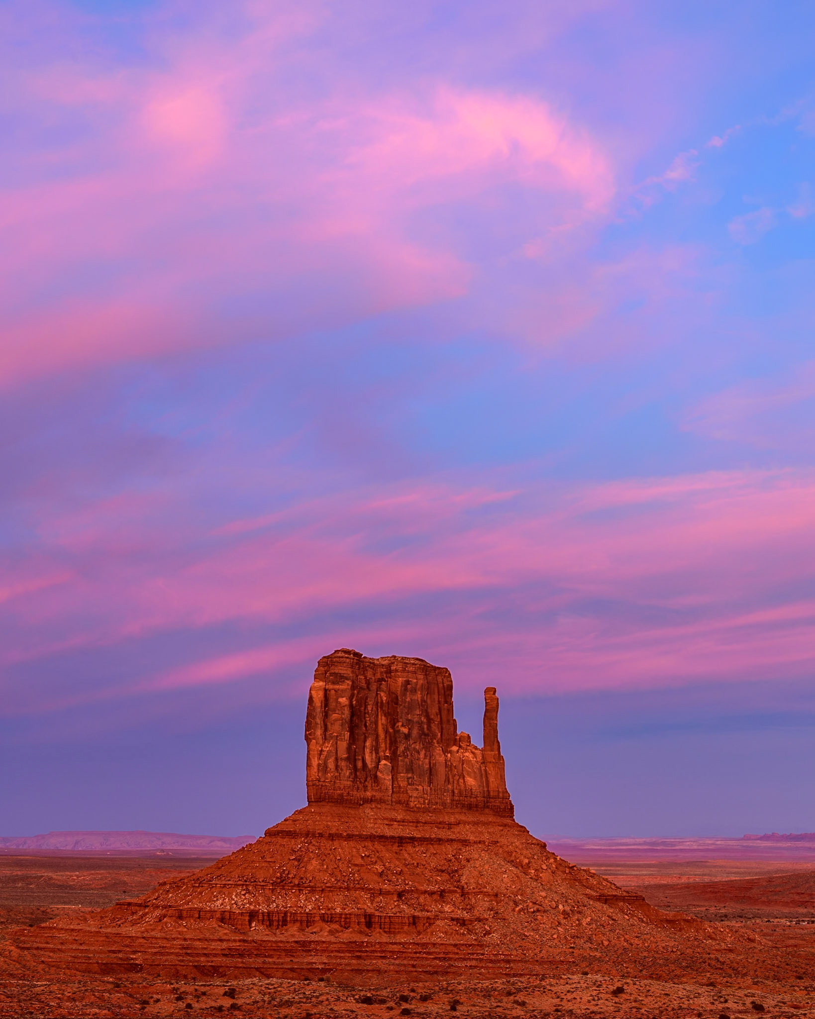 I have visited Monument Valley many times, but I have never seen a sunset like on this evening. The sky behind me was on fire.  After the sunset, the clouds glowed a beautiful pink which tinted the red rocks to a color I'd never seen before in the west. To capture the uniqueness of the color and beauty of the moment I focused on a simple mitten.