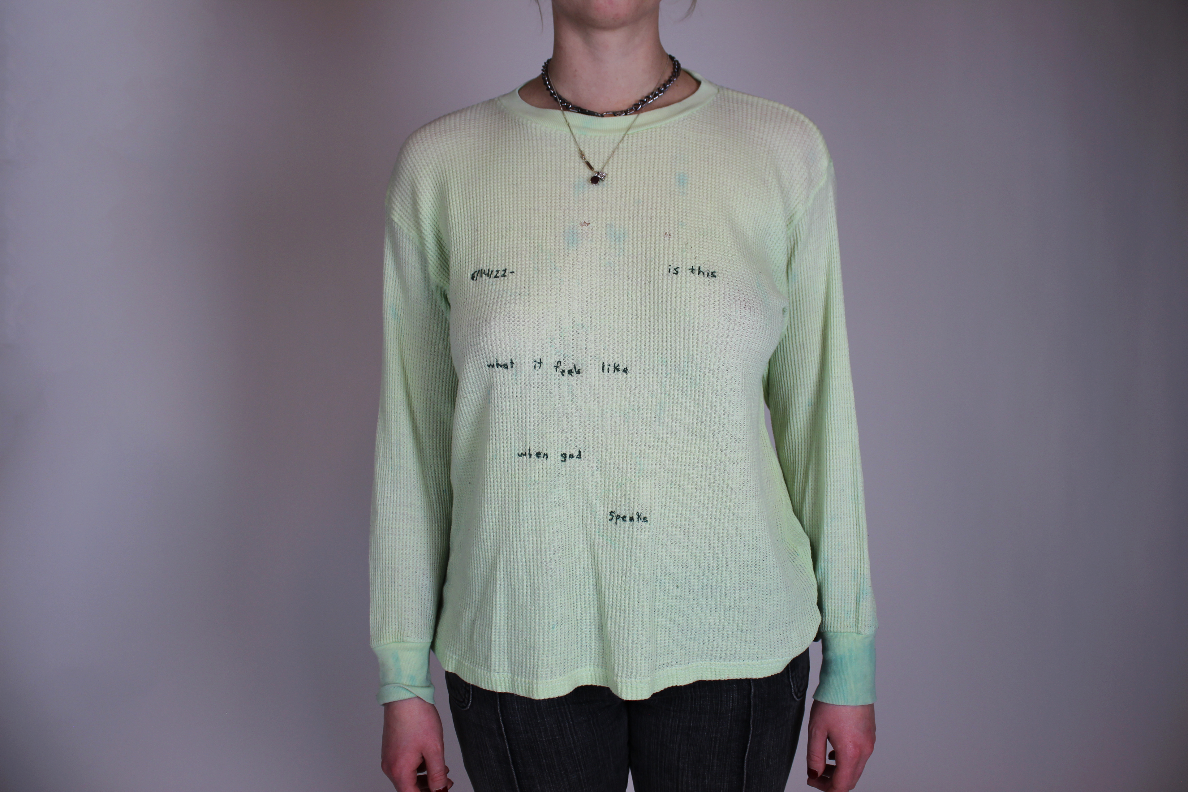 a long sleeve green shirt with embroidery reading "6/14/22- is this what it feels like when god speaks"
