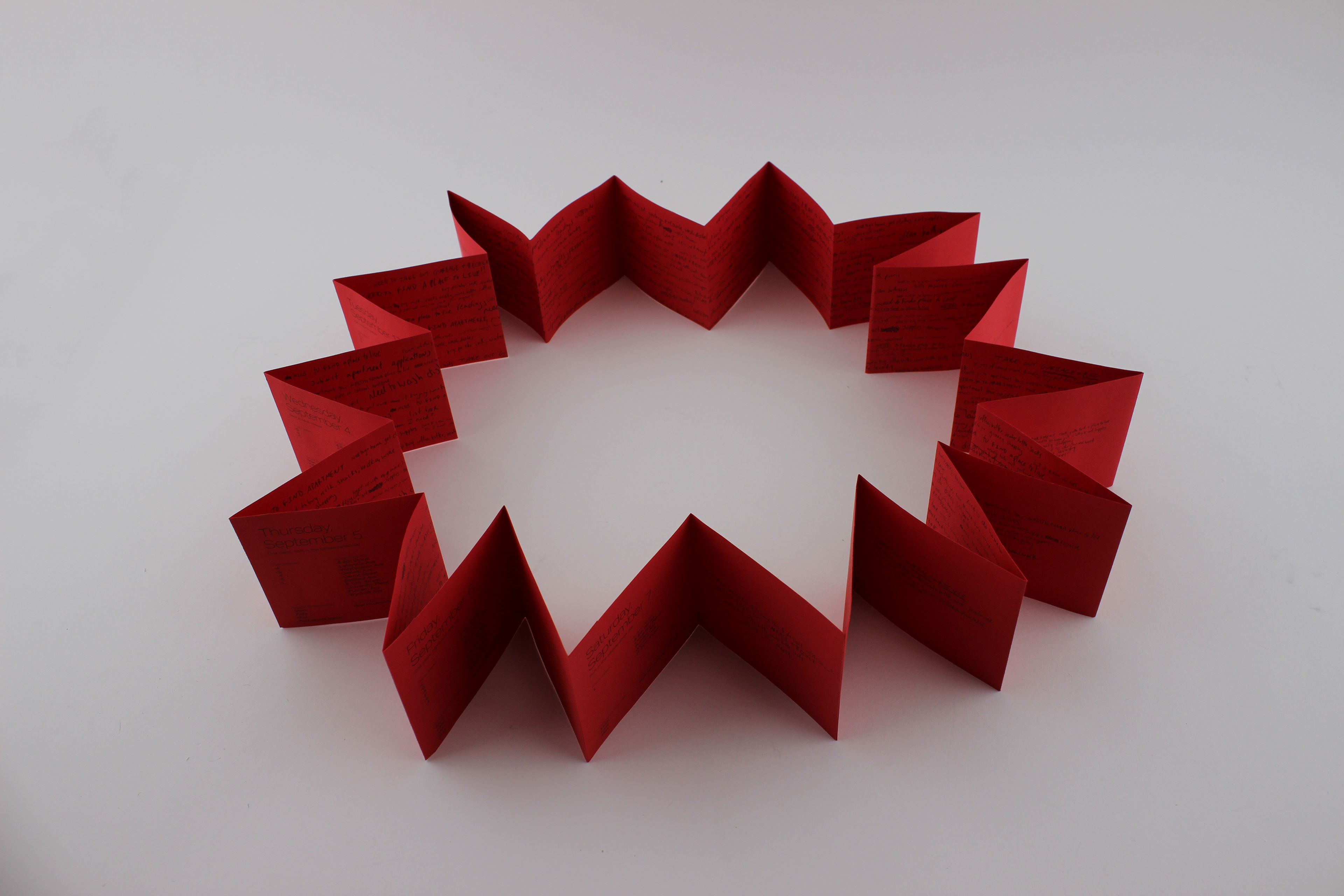 a bright red, closed loop accordion book from above