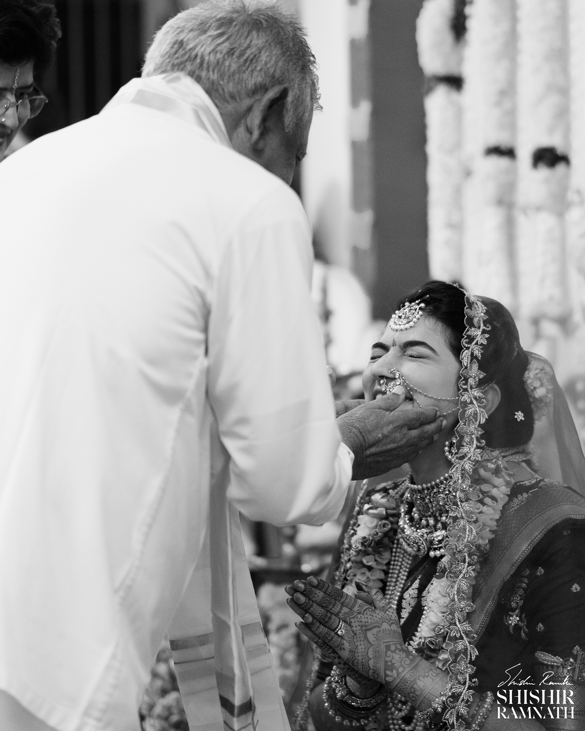 A woman exudes joy as she receives blessings from her grandfather during her wedding ceremony