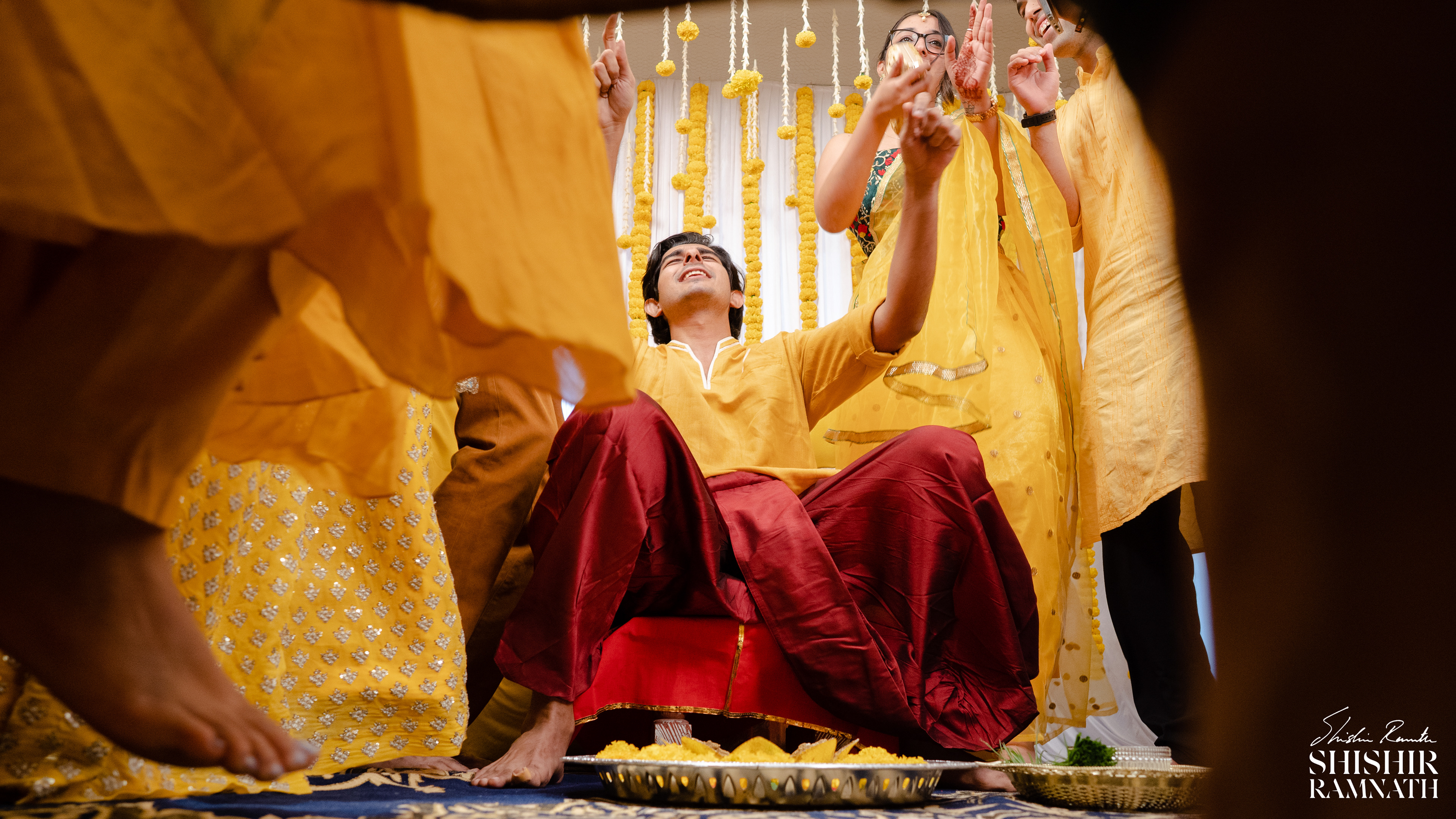 haldi image of a groom amidst dancing feet 