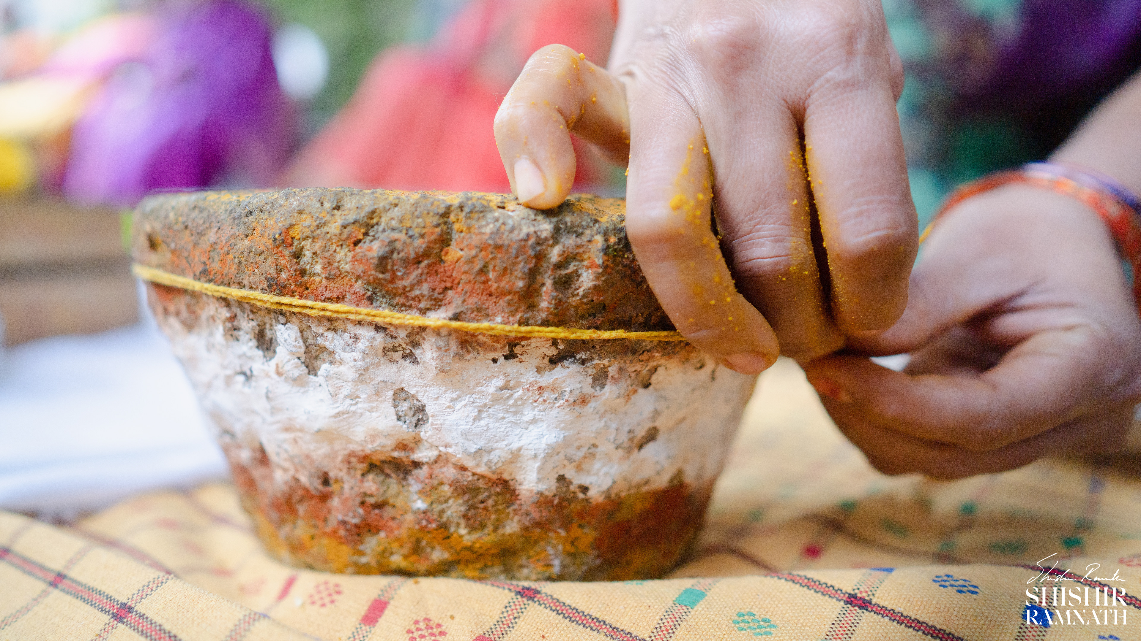 a sacred thread is being wound on a holy rock as a telugu wedding ritual