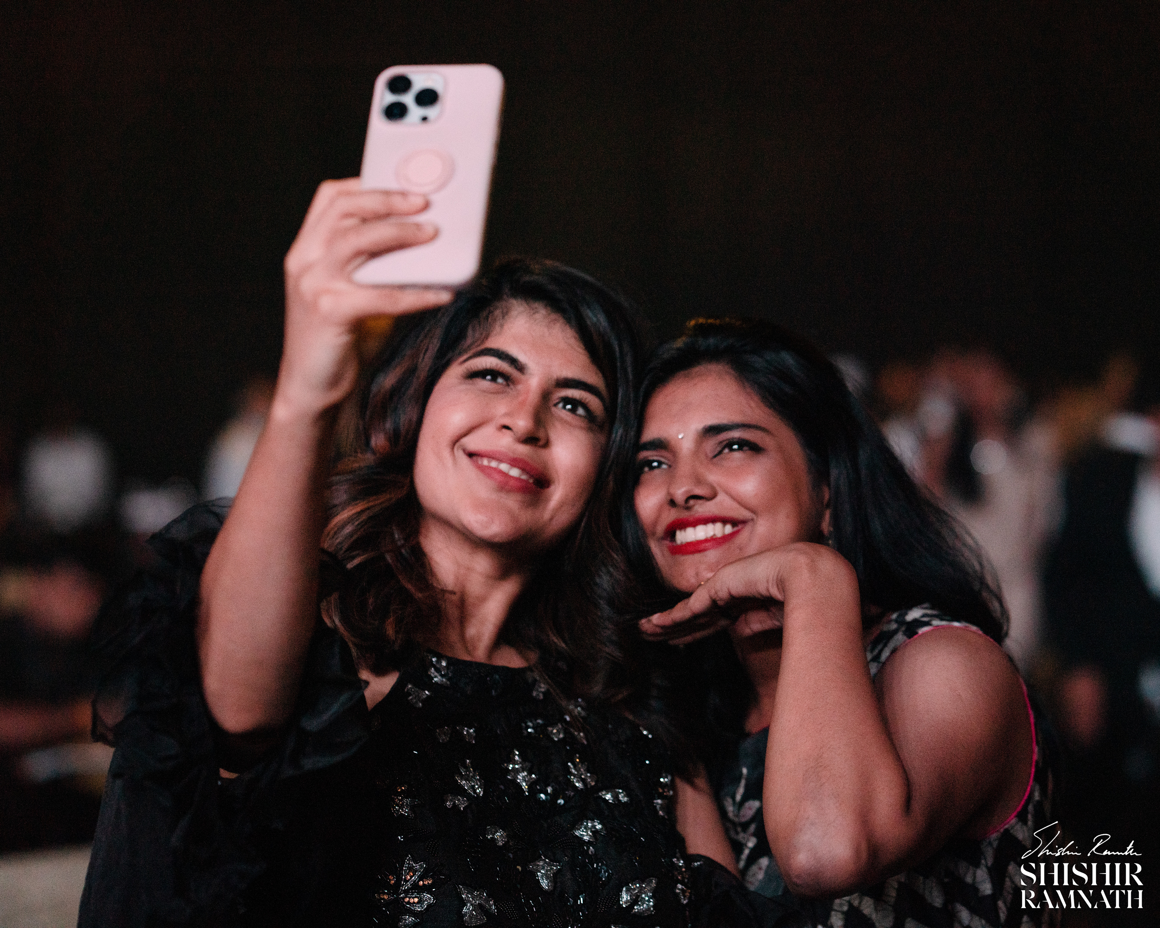 bridesmaids taking a selfie in the crowd at a telugu wedding 
