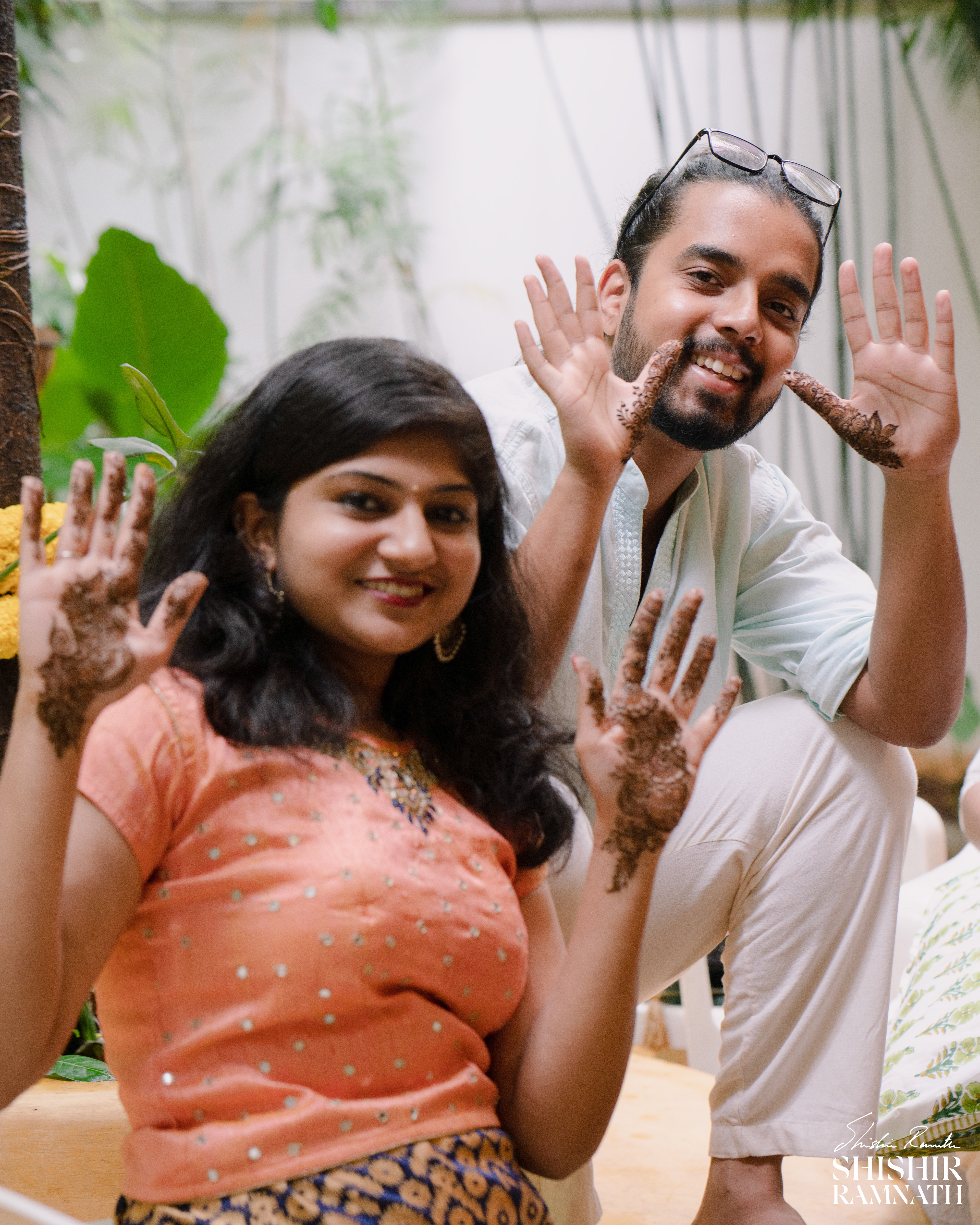 a man and woman showing off their mehndi to shishir ramnath