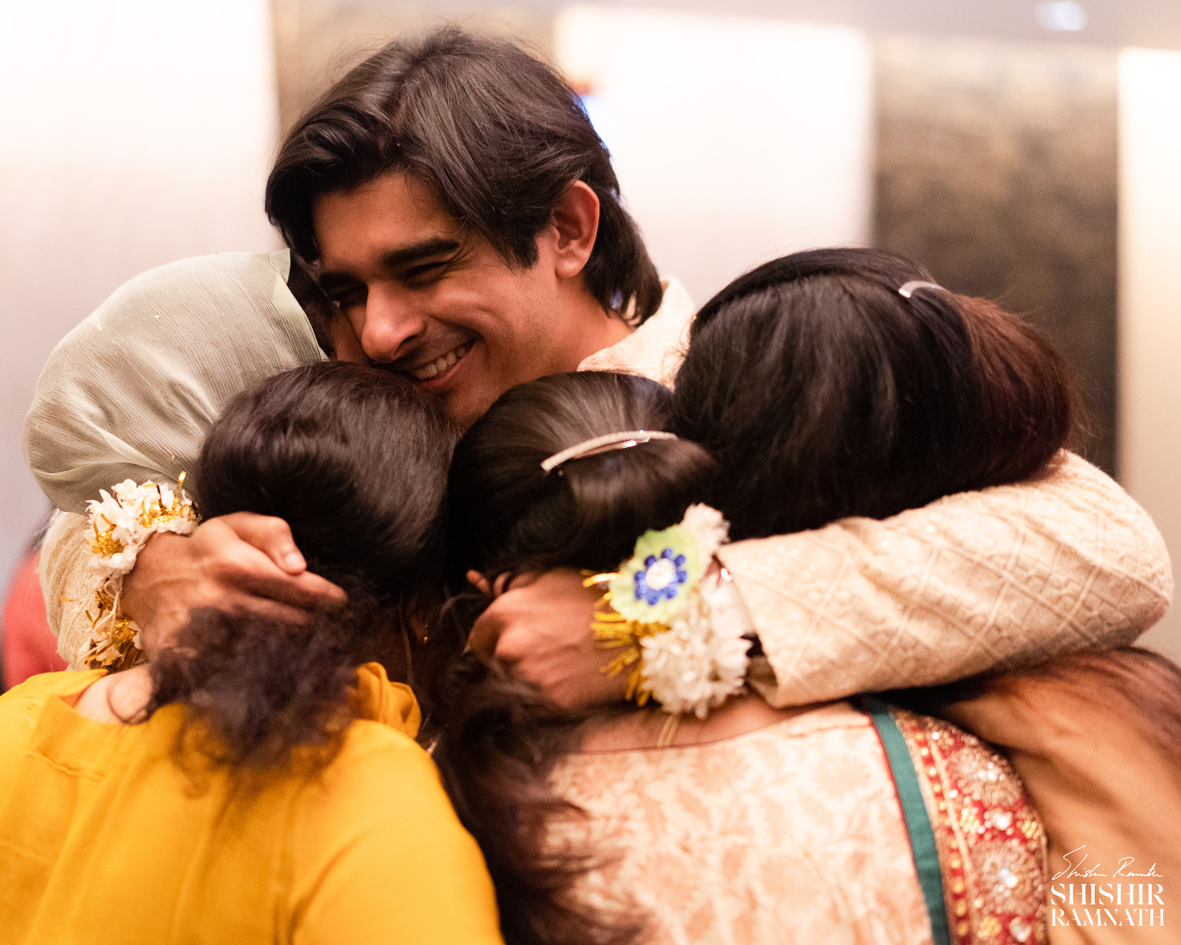 heartwarming hugs of a man with his sisters at his wedding