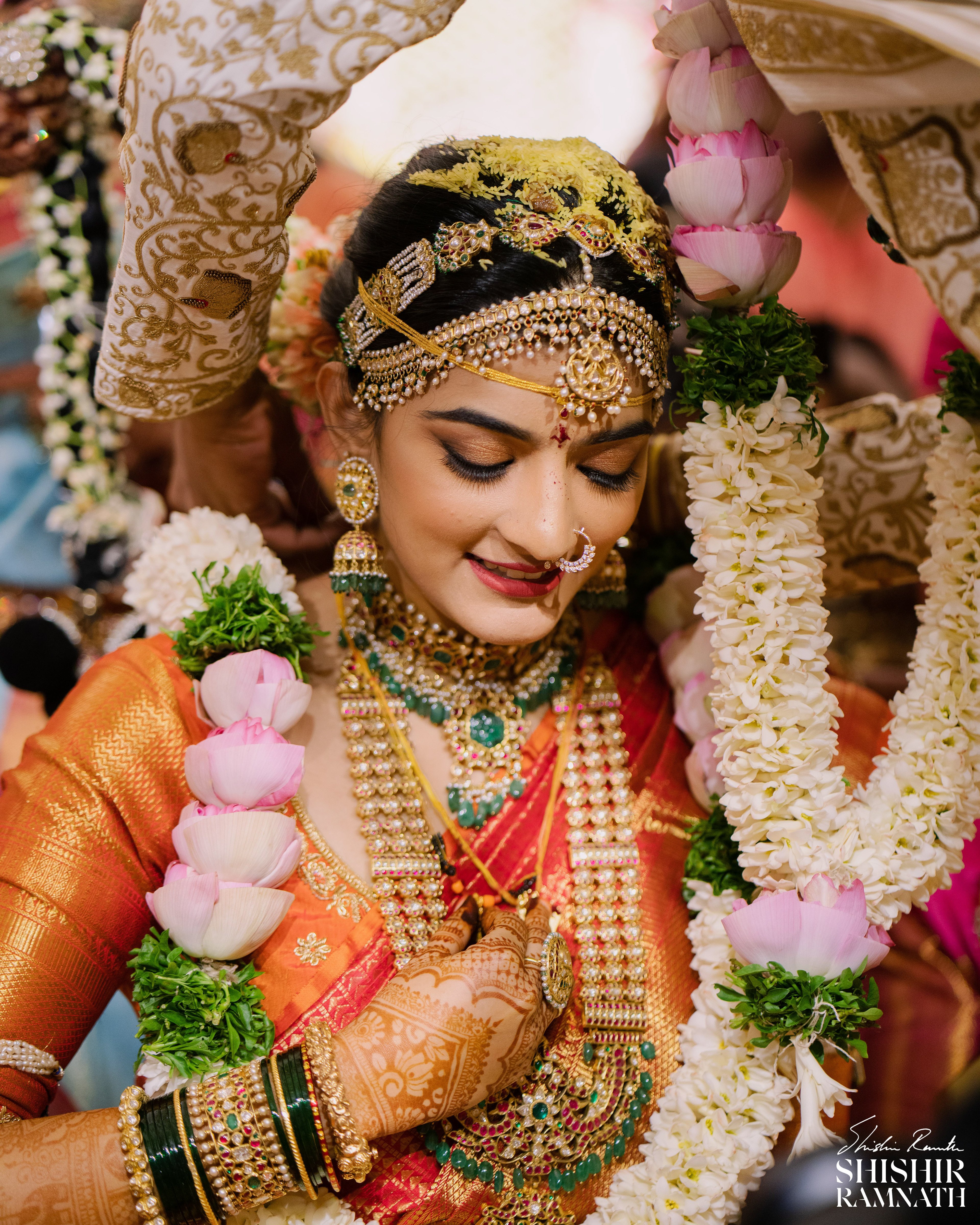an indian bride closes her eyes as the mangalsutra is tied by the groom
