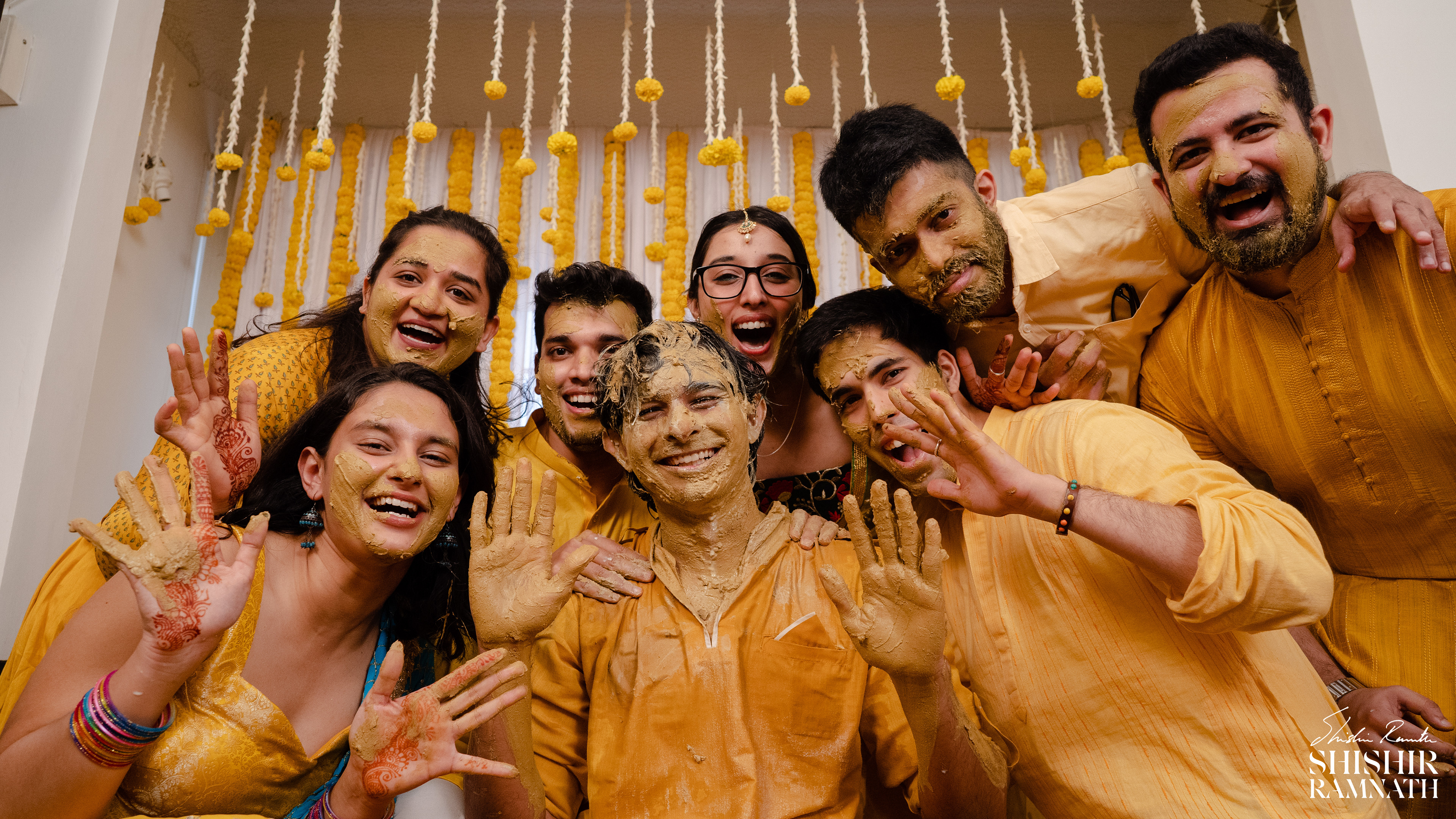 a group of friends smiling at the camera and posing at a haldi event in chennai