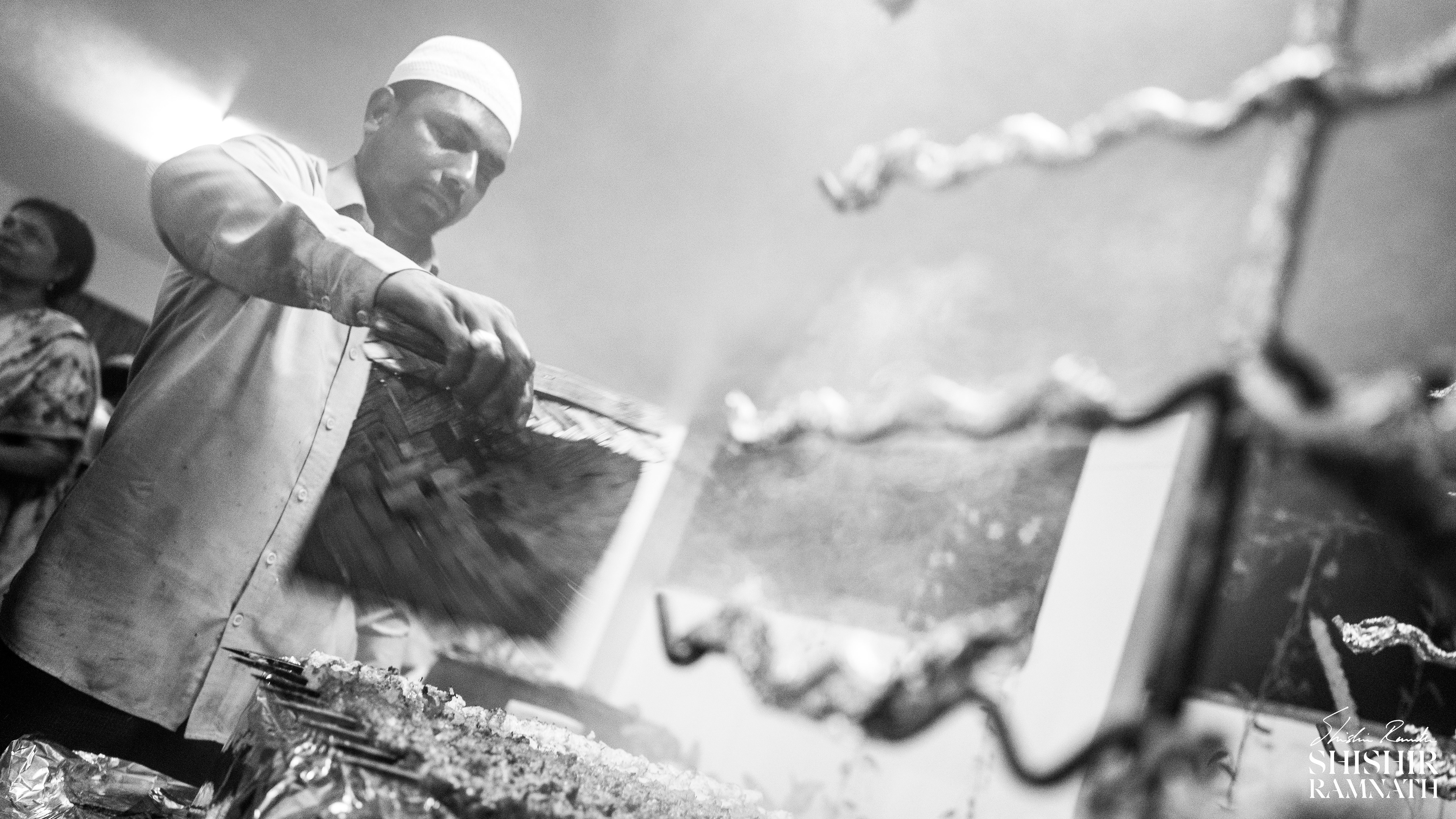 wide angle black and white photograph of a chef making kebabs 