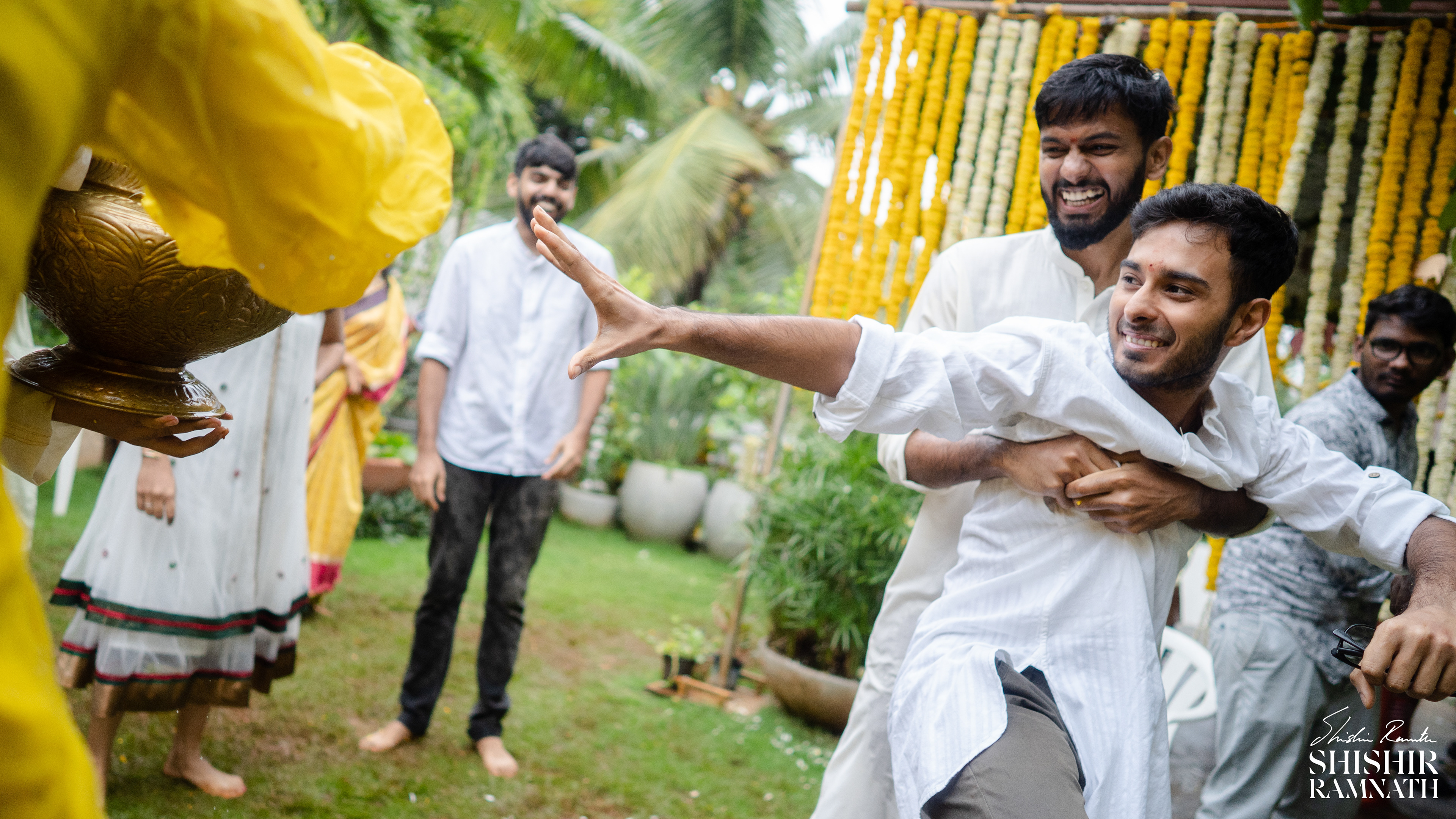 a man moments before he's forcibly drenched in water as a part of a pre wedding telugu wedding ritual