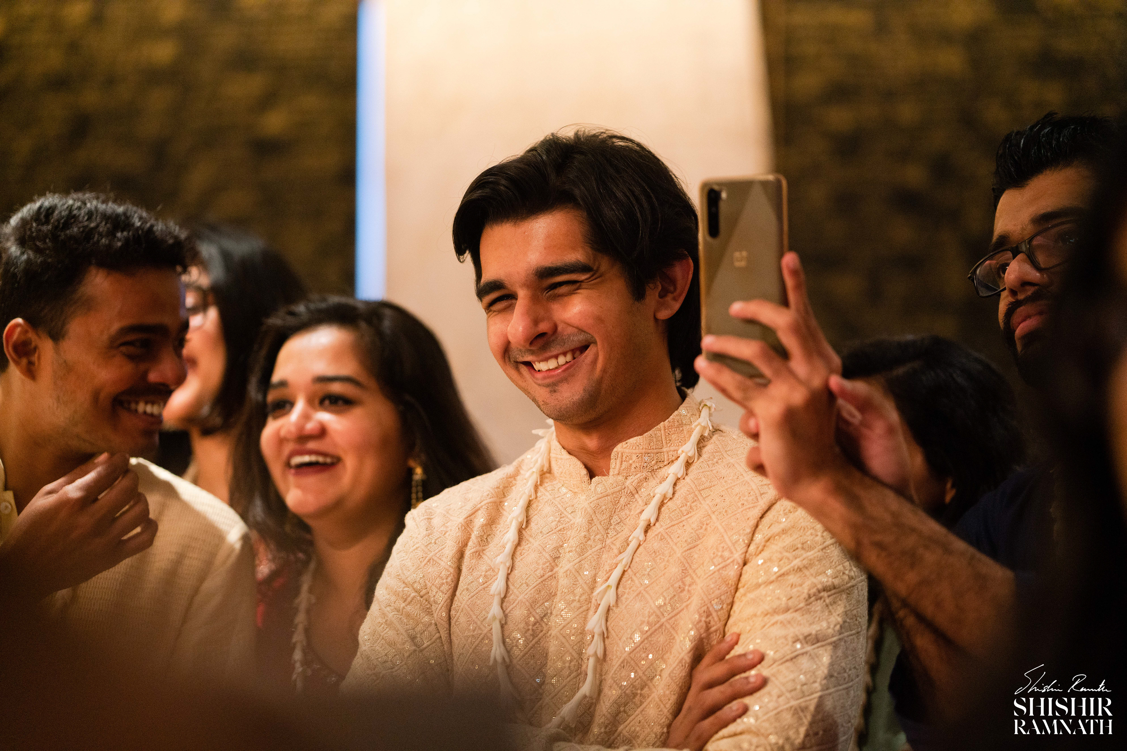 groom looks at the bride and smiles during a wedding event among the crowd