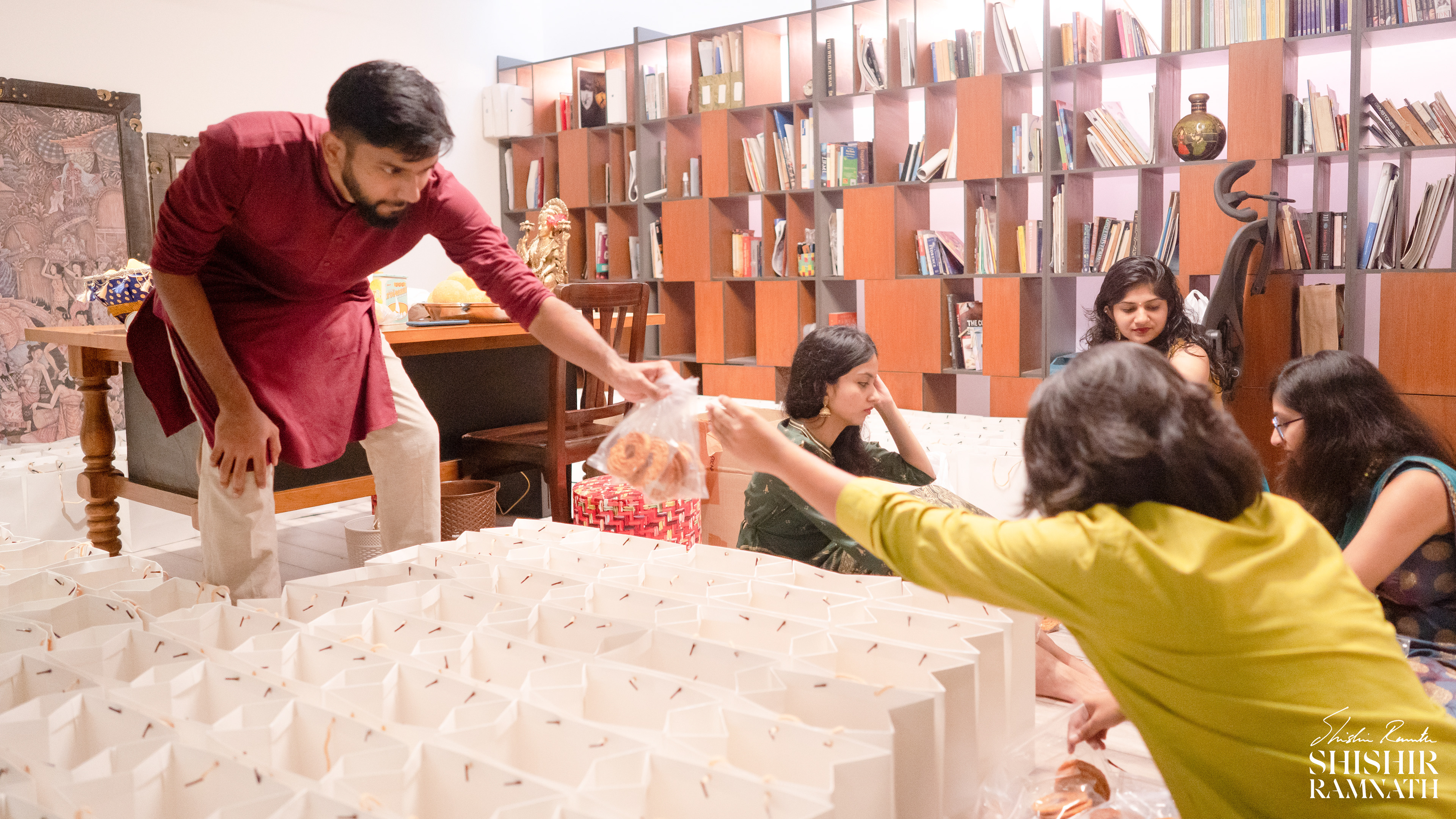 people preparing gift hampers to be given to the guests at a mehndi