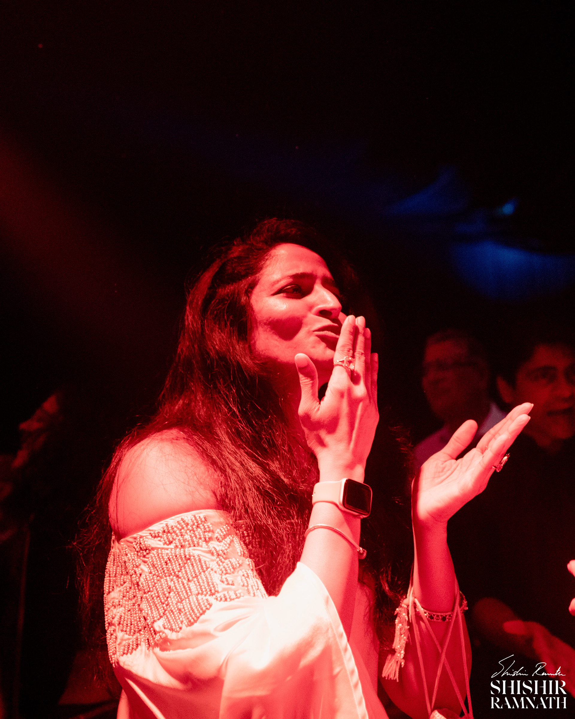the brides aunt blows kisses at the couple as they share a moment