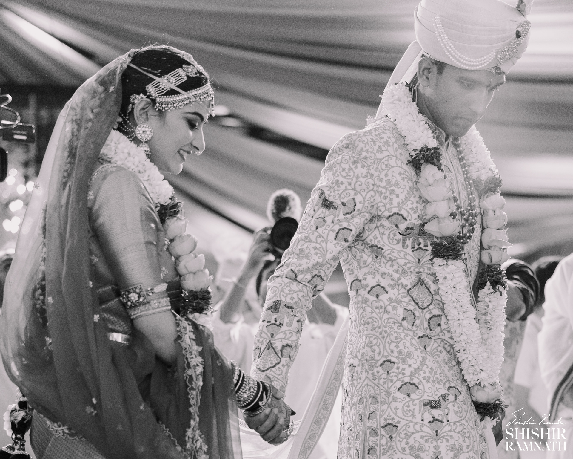 a black and white image of. a bride and a grom during their pheras, photograph by shishir ramnath