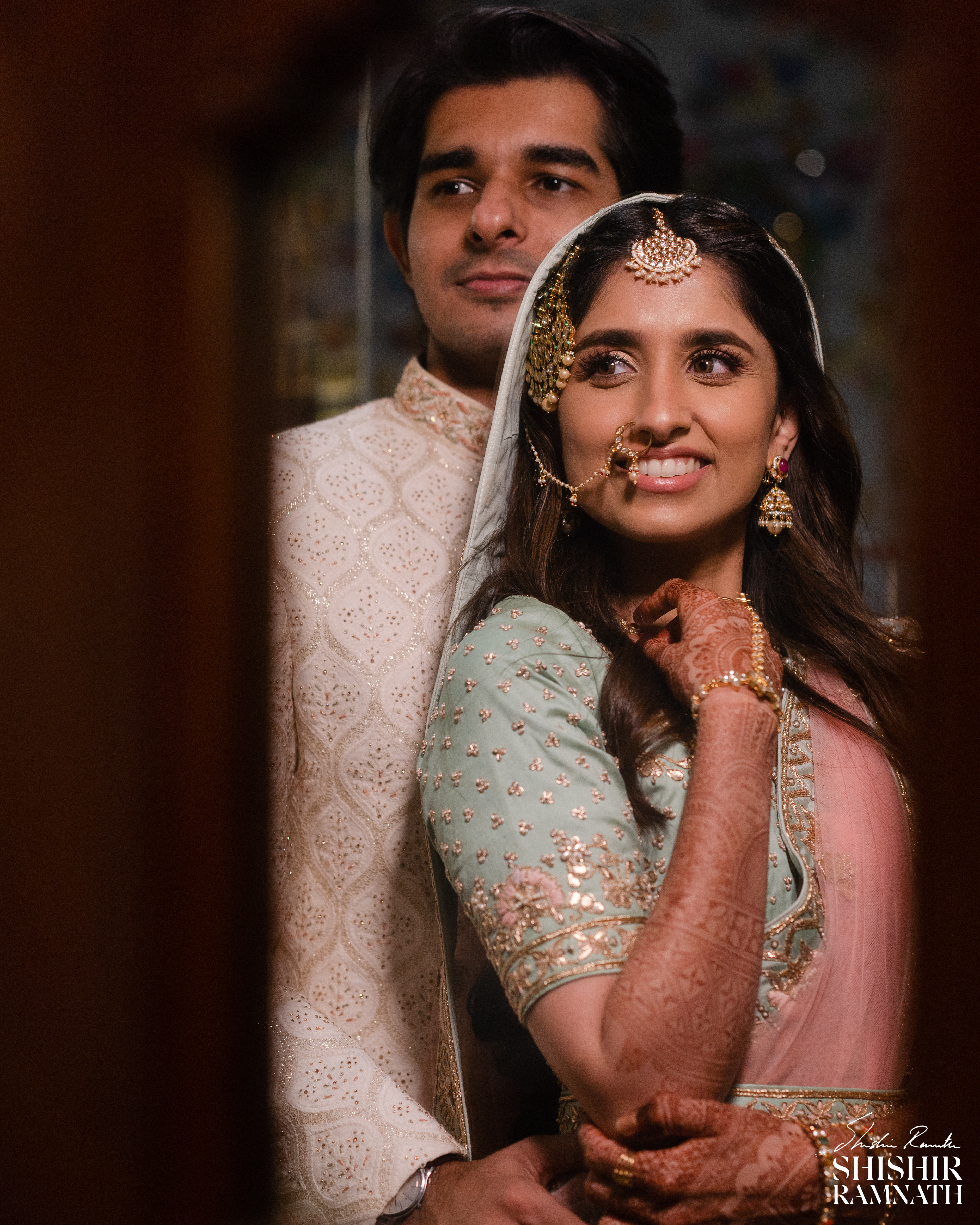 a couple look into the mirror to take a moment t admire their outfits at a wedding in chennai