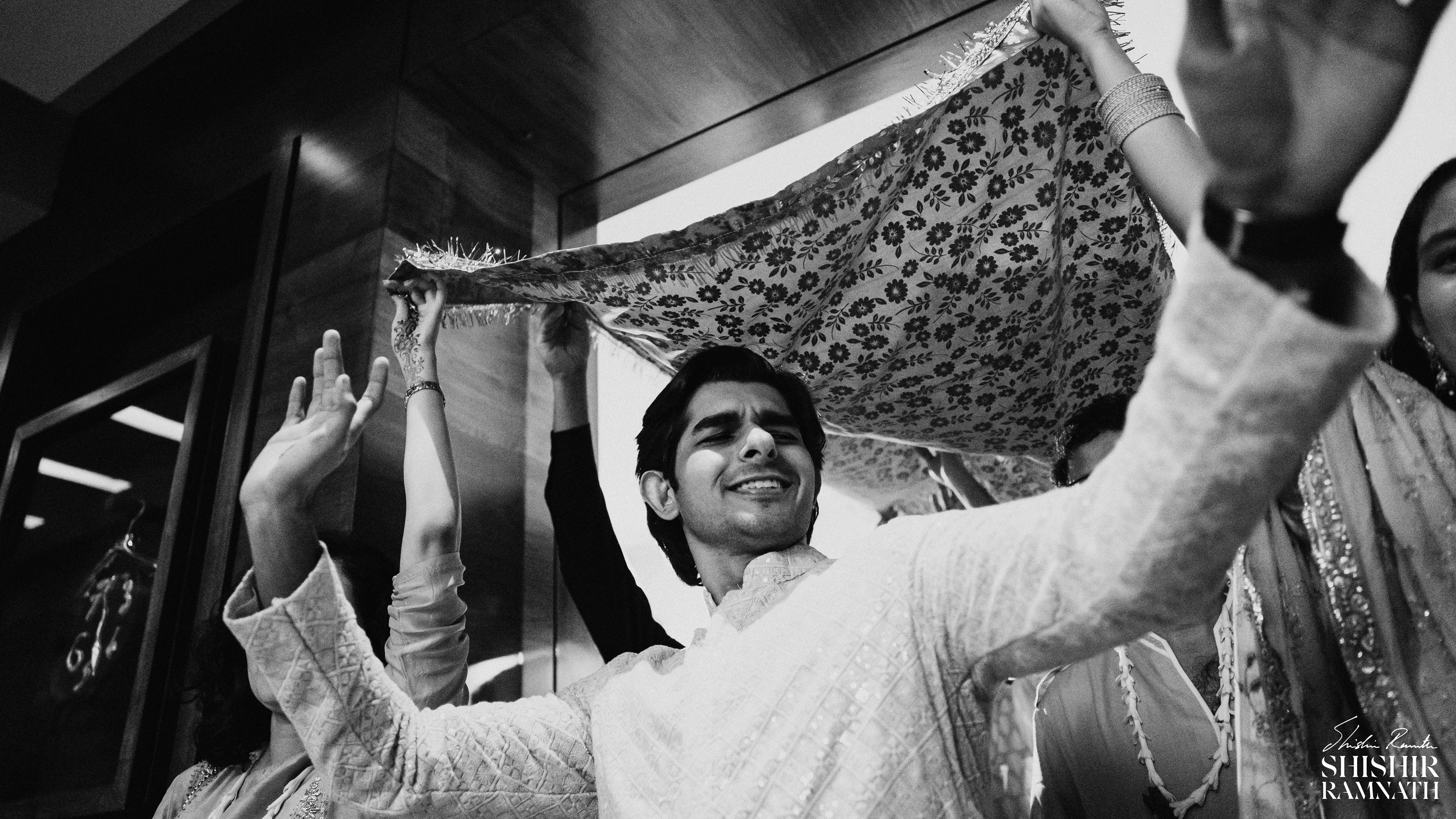 dancing groom entry in black and white shot on a wide angle by shishir ramnath