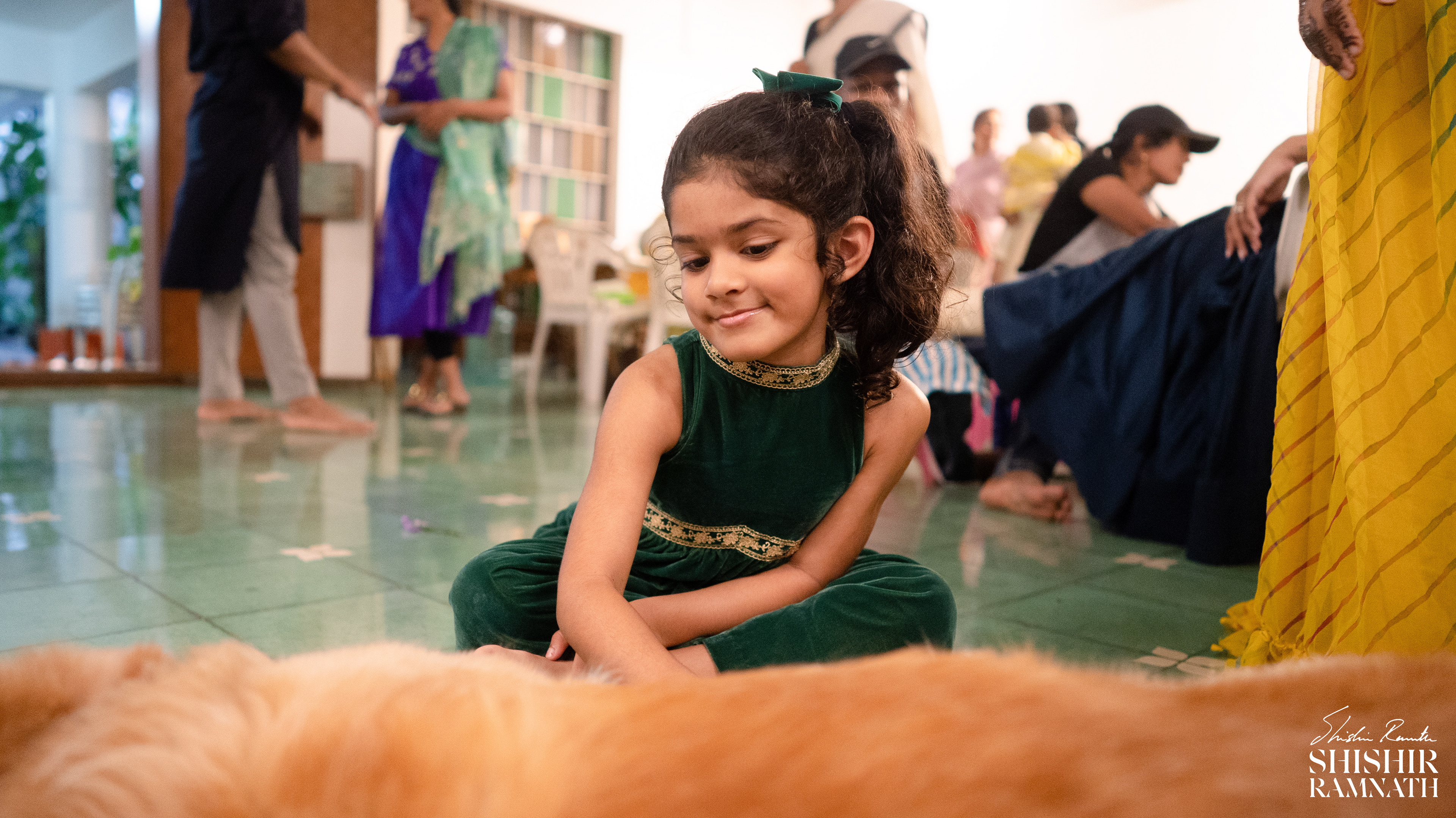 a young girl petting her dog at a mehndi venue