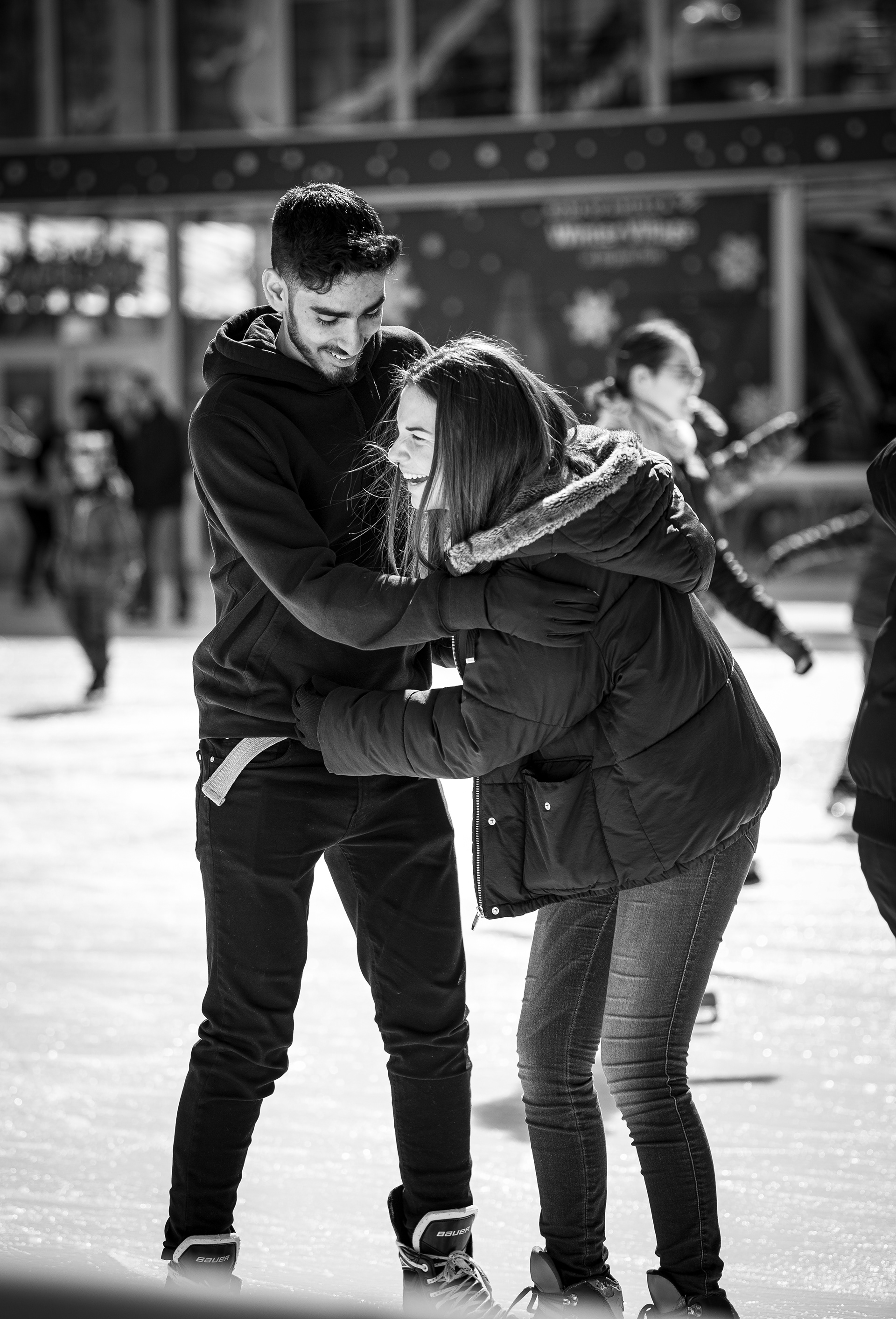 A woman’s balance is maintained by her partner while ice skating in Manhattan, NY.