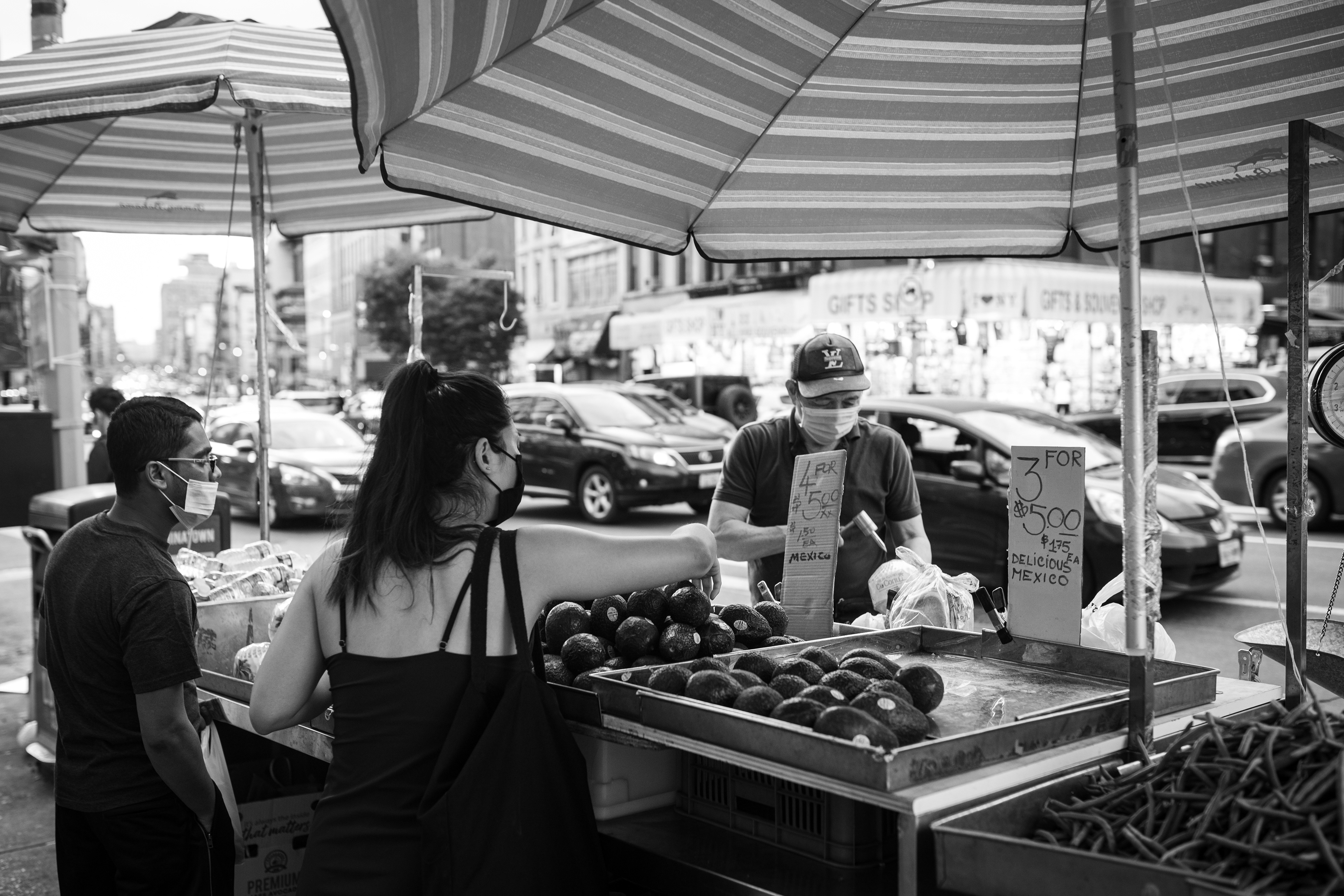 A man maintains his fruit and vegetable cart in Chinatown, NY, during the the height of the COVID-19 pandemic. 