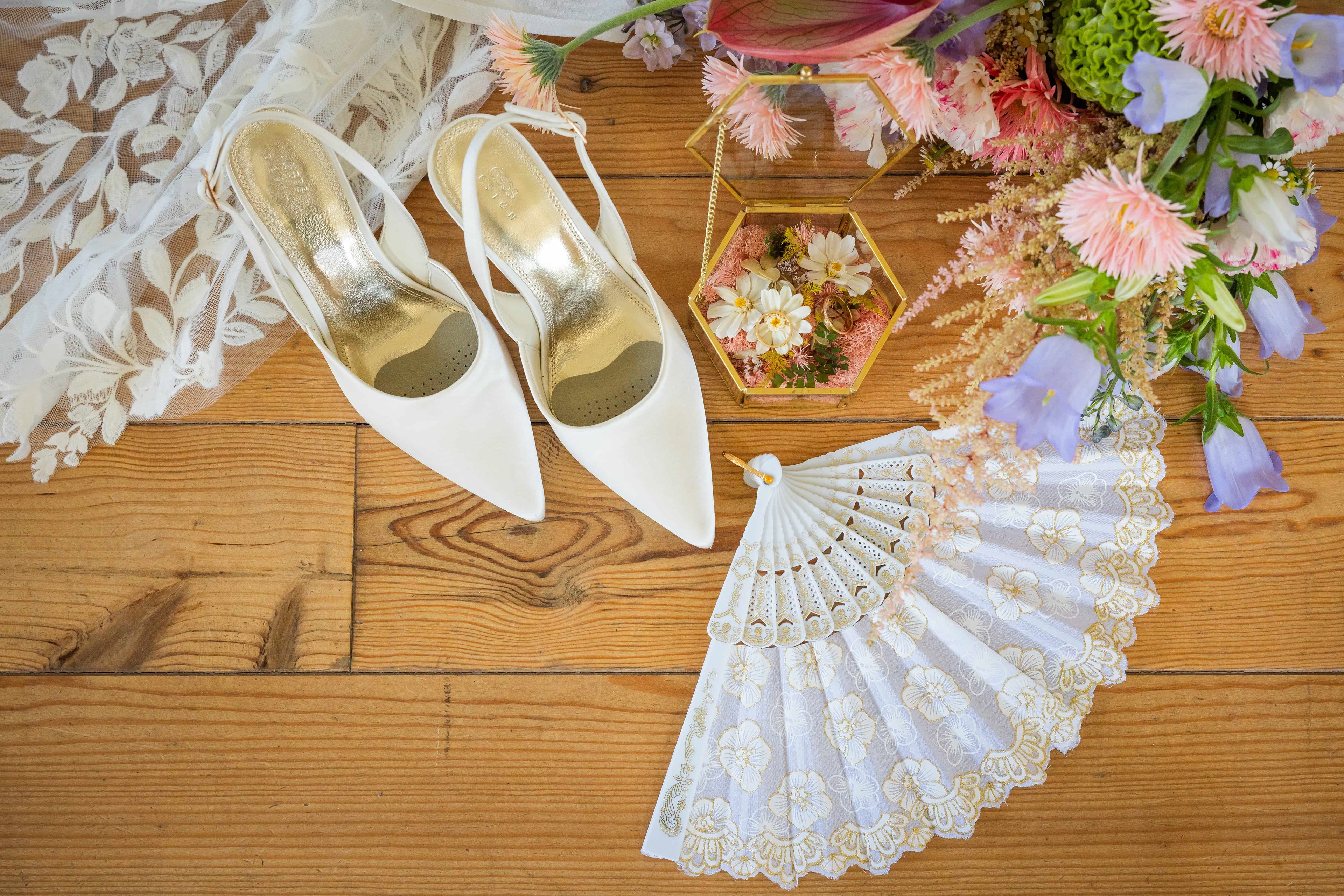 Photo des détails - chaussures éventail et bouquet de la mariée