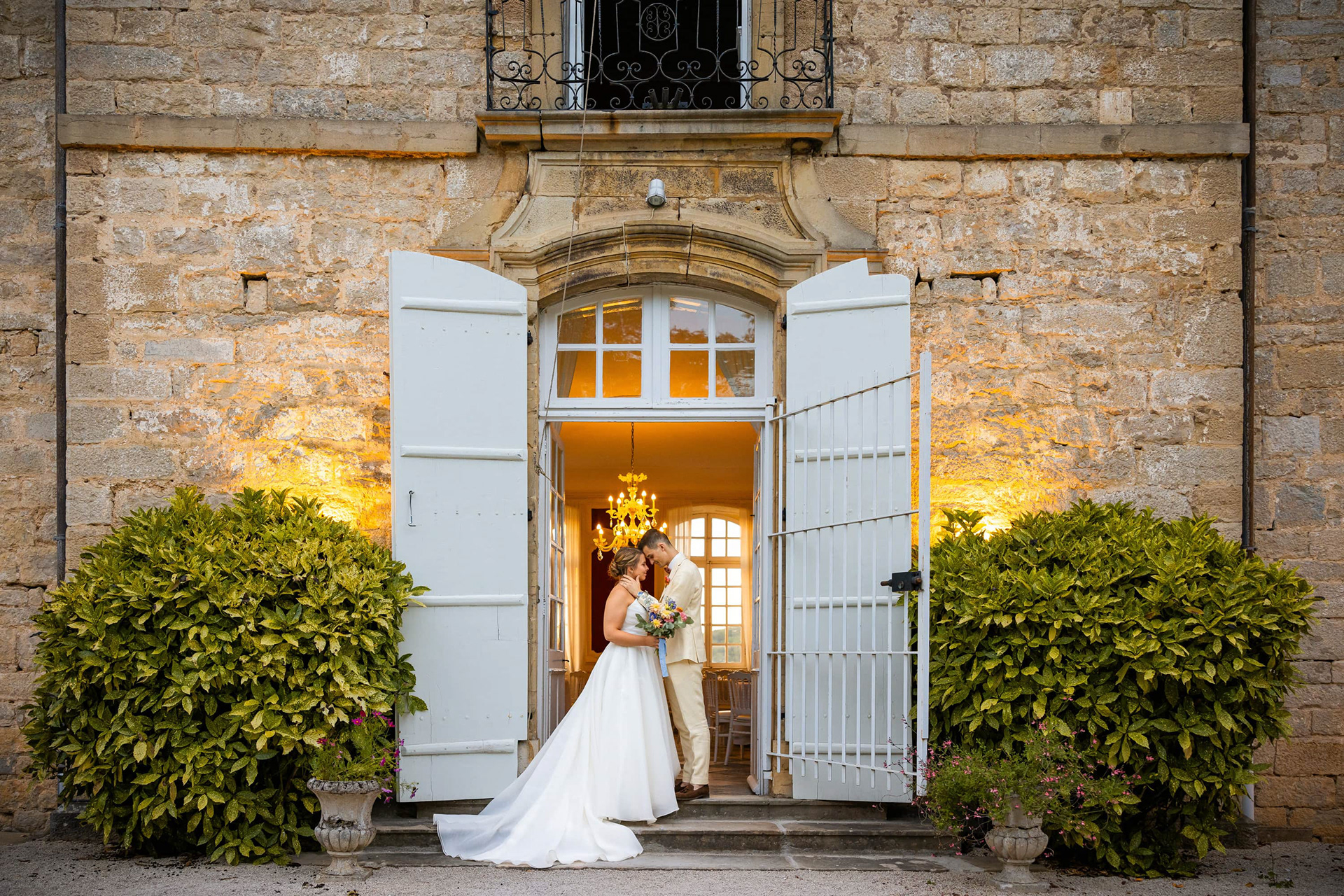 Couple de marié se tenant debout devant la porte d'un château