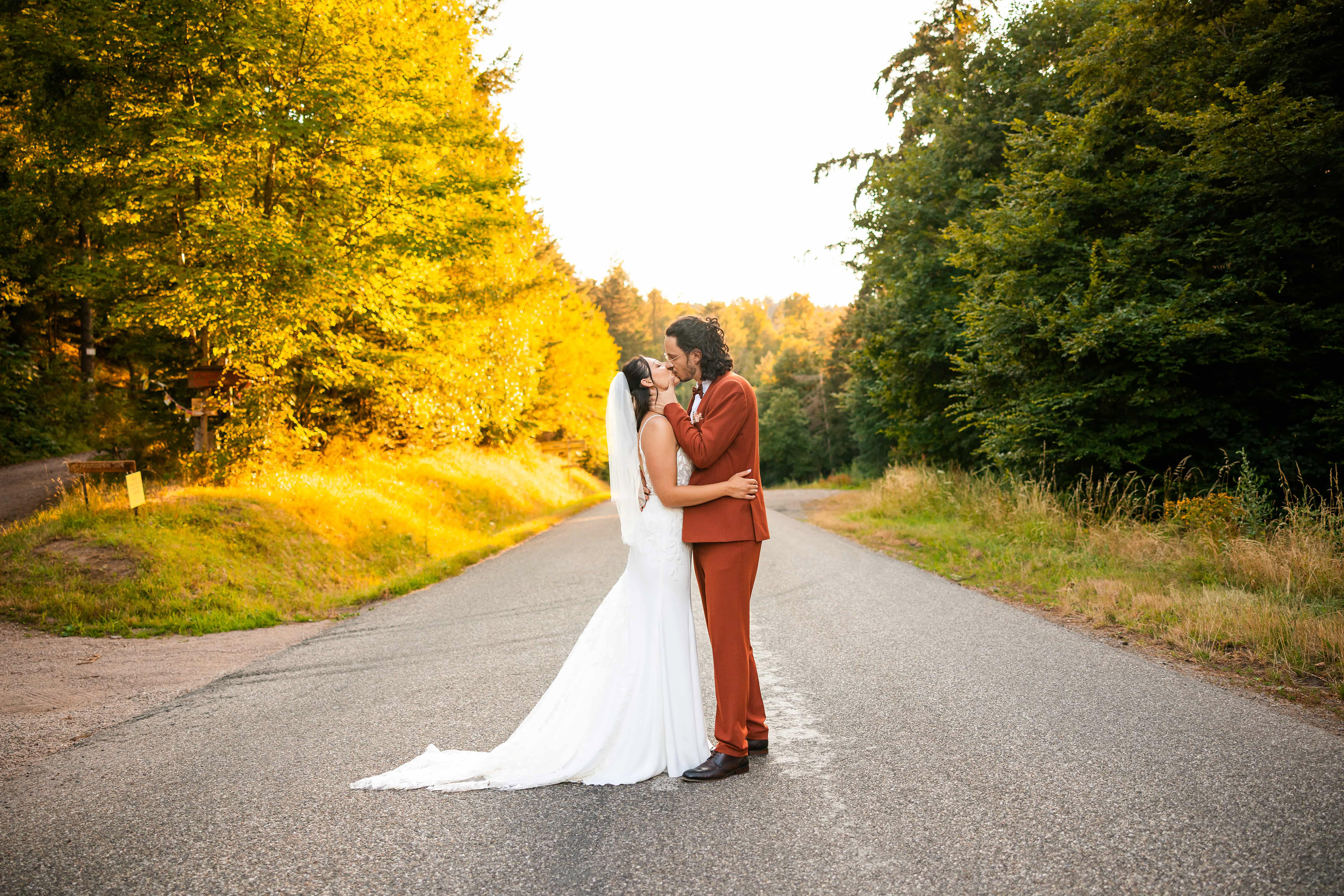 mariés qui s’embrassent sur une route en forêt alsace