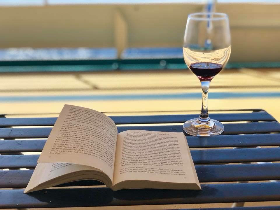 Vin och en bok på däck