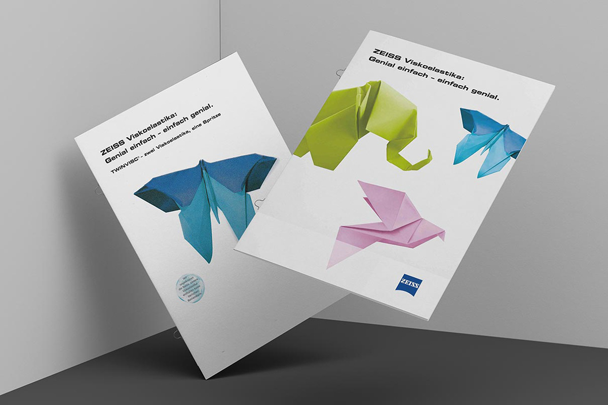 Brochures with hand-folded origami objects on the cover. In the shape of a butterfly, a dove, and an elephant.