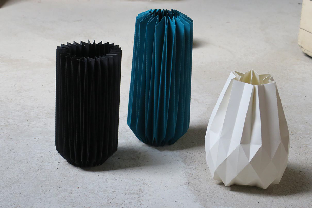Three paper vases in different colors for the design of an exhibition stand.