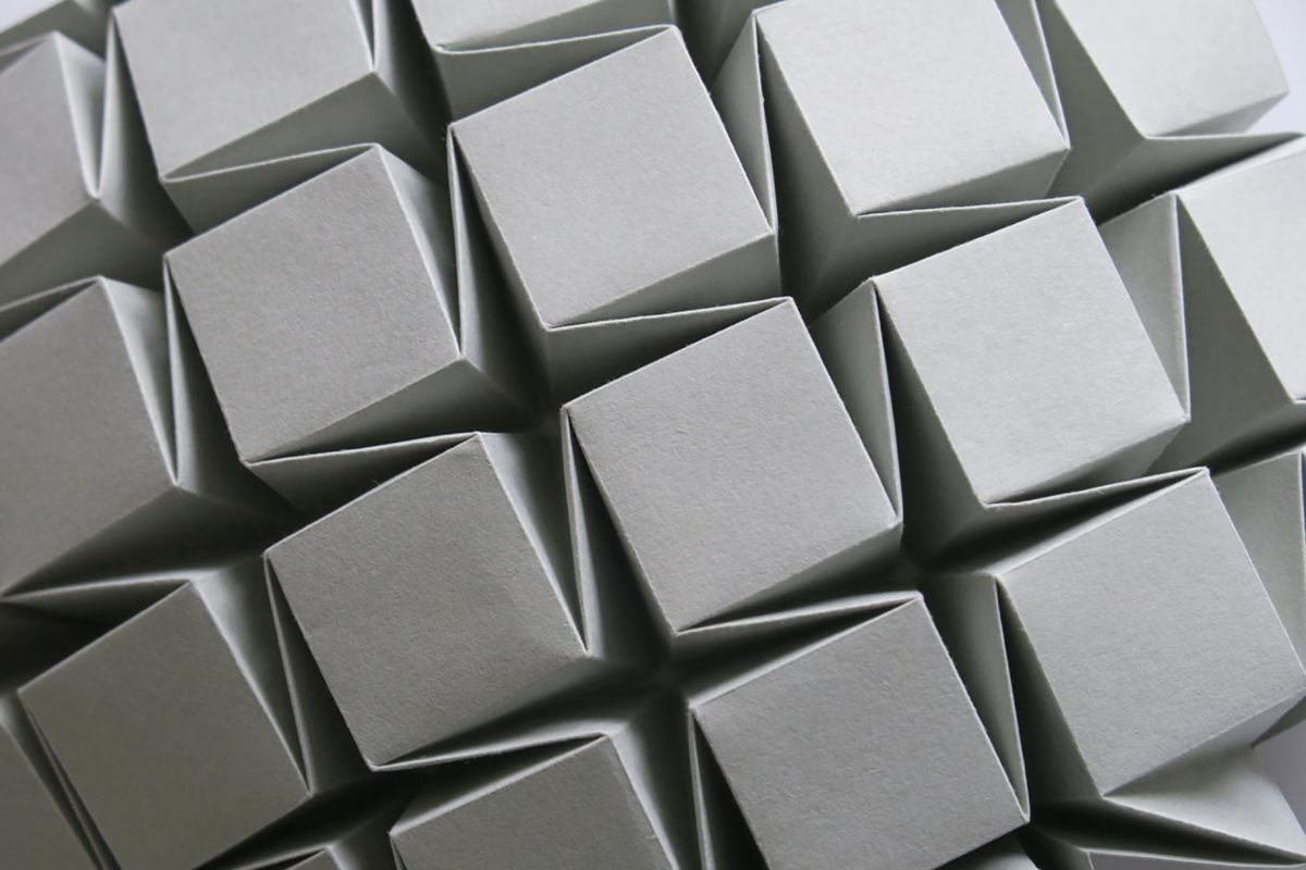 Close-up of a grey origami structure, three-dimensional tessellation.