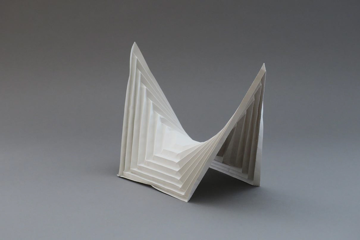Modified saddle surface made of grey paper for the design of a concrete bridge.