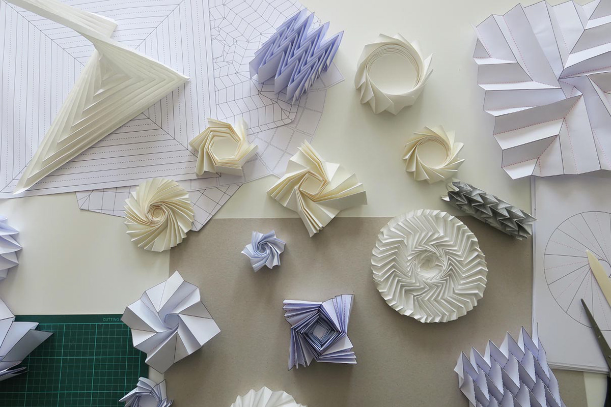 A work table full of folding structures for technical applications such as automotive or aerospace.