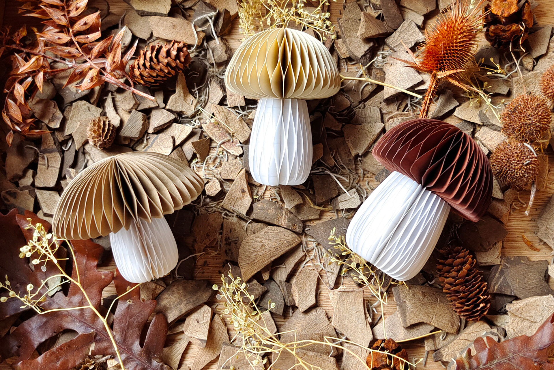 Three different sized paper mushrooms in shades of brown, a beautiful decoration for autumn or the Christmas season.