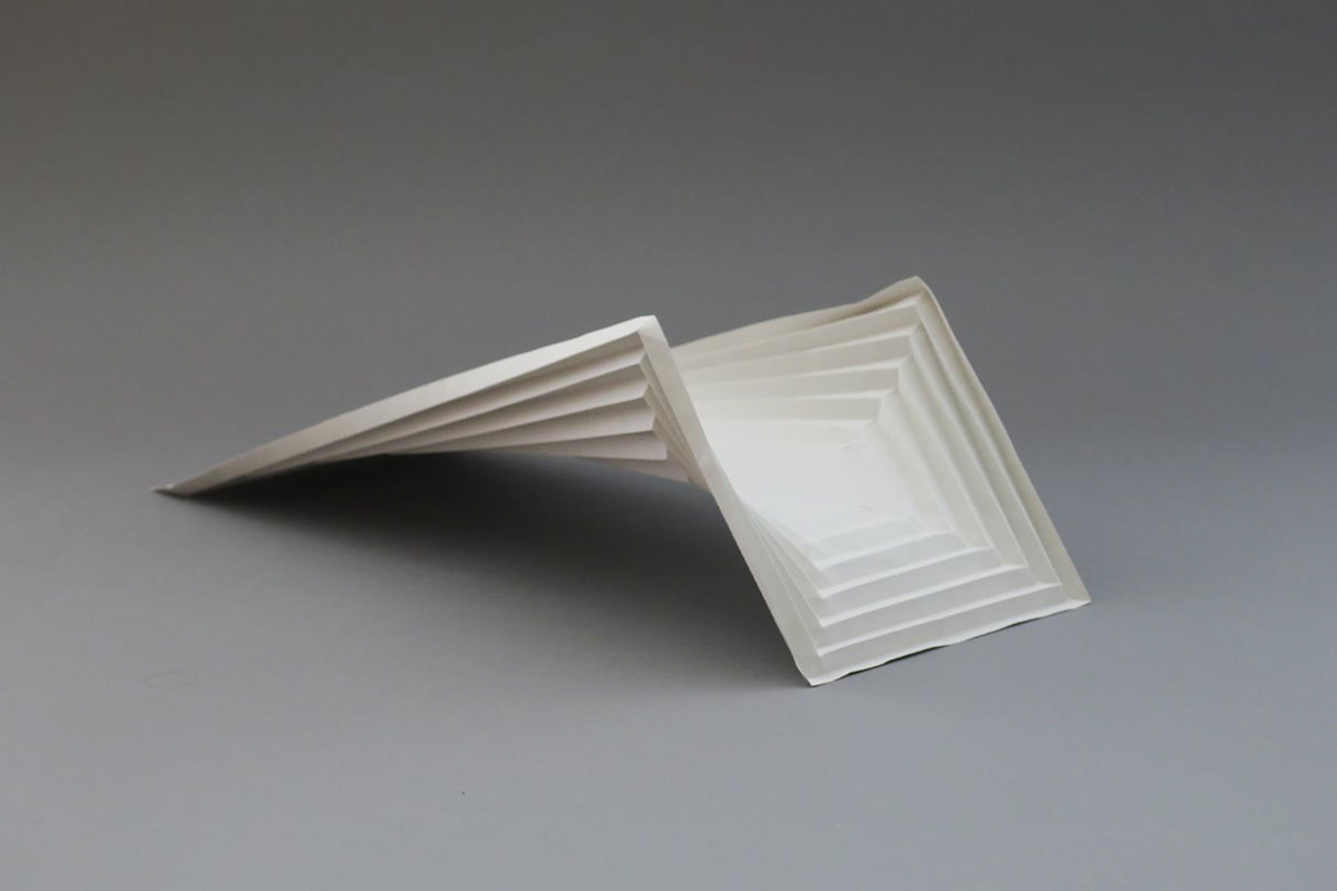 Modified saddle surface made of grey paper for the design of a concrete bridge.