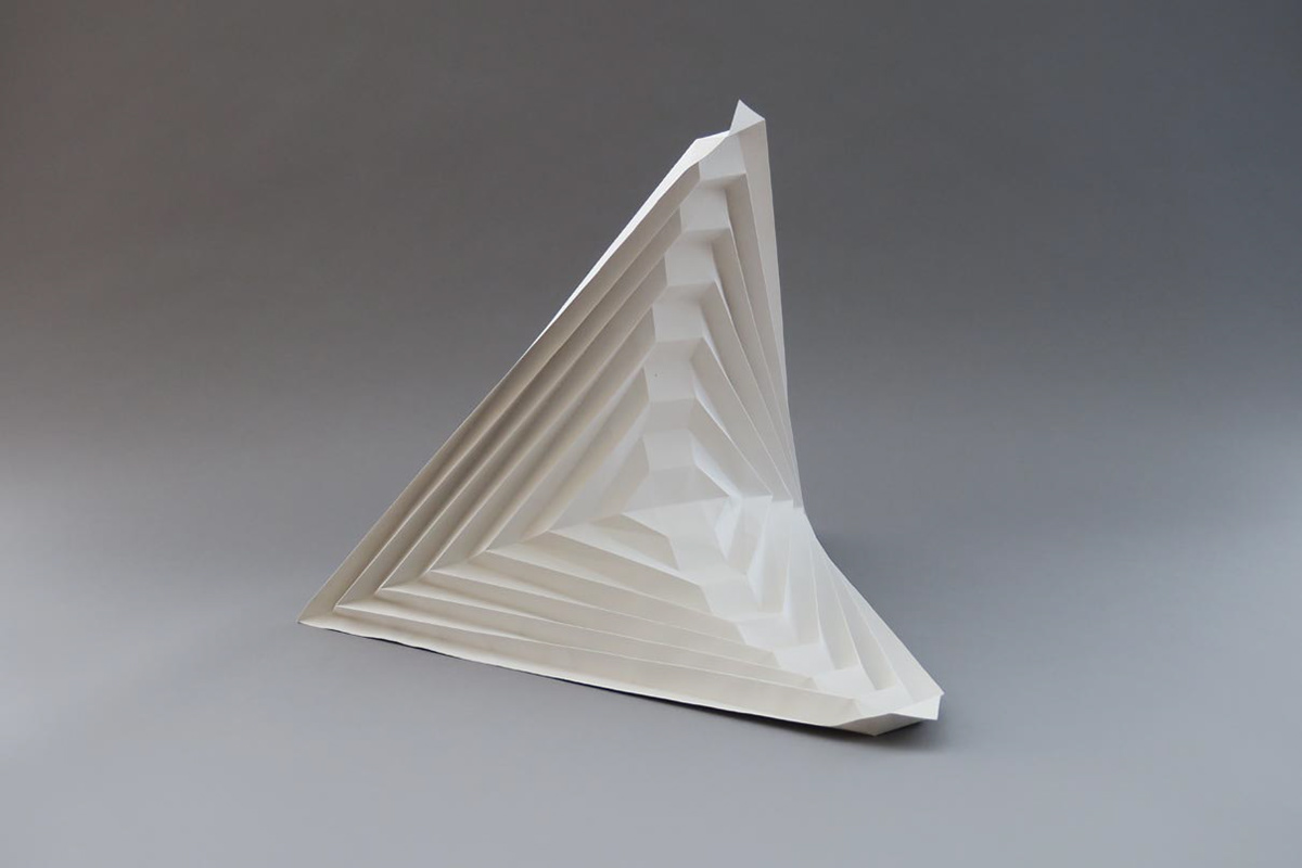 Folded saddle surface made of grey paper as an illustrative object for the research project.