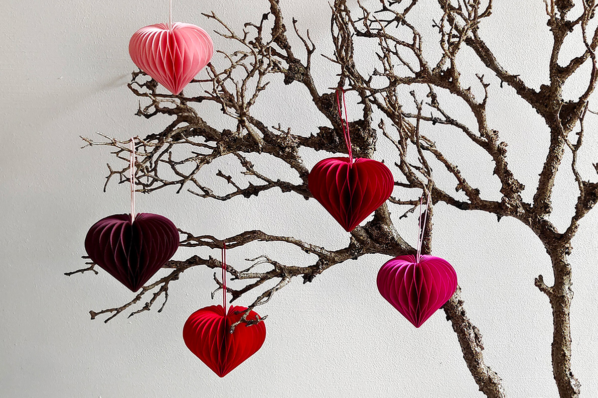 Five different honeycomb paper hearts in different shades of red, designed and handcrafted by Kristina Wißling.