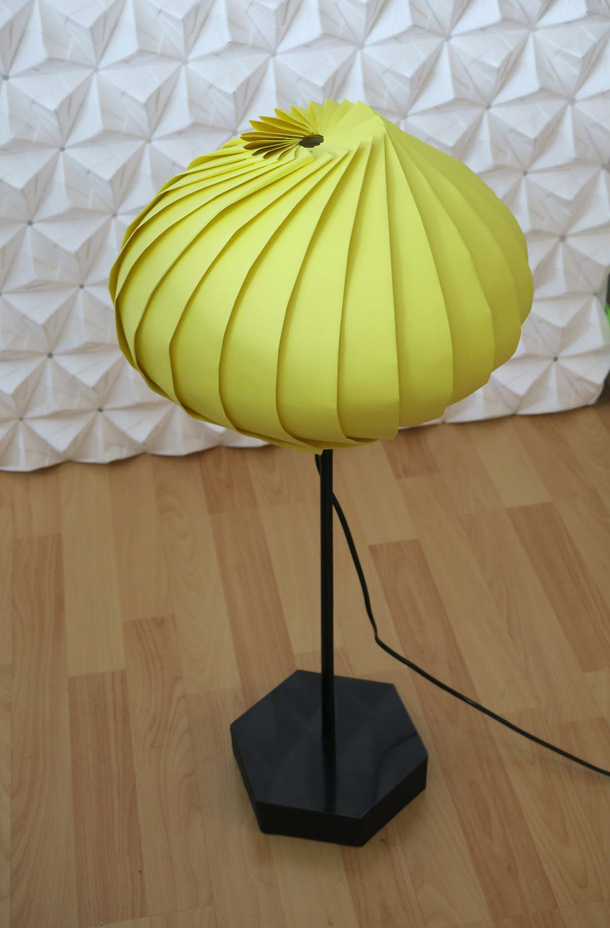 A paper floor lamp, handcrafted from a variety of materials. The lampshade was folded using the origami technique.