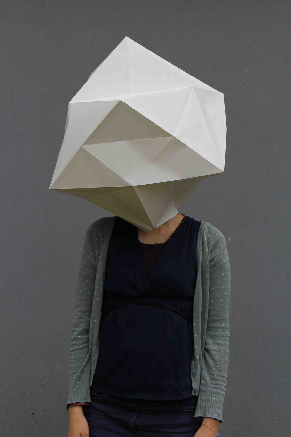 A student with her cardboard mask. A geometric fold that covers the entire head.