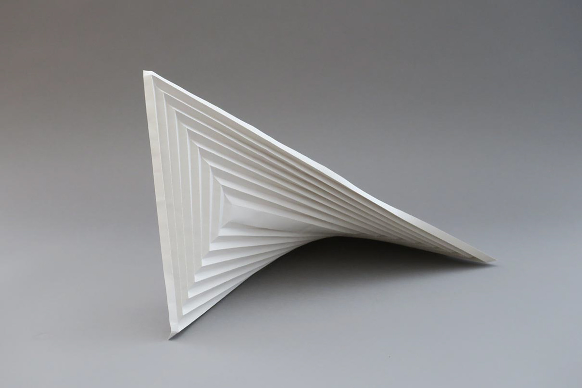 Modified saddle surface made of grey paper for the design of a concrete bridge.