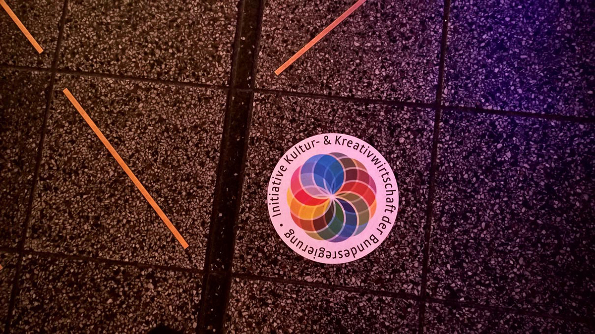 Sticker with the logo of the Federal Government’s Cultural and Creative Industries Initiative in the entrance hall of the event.