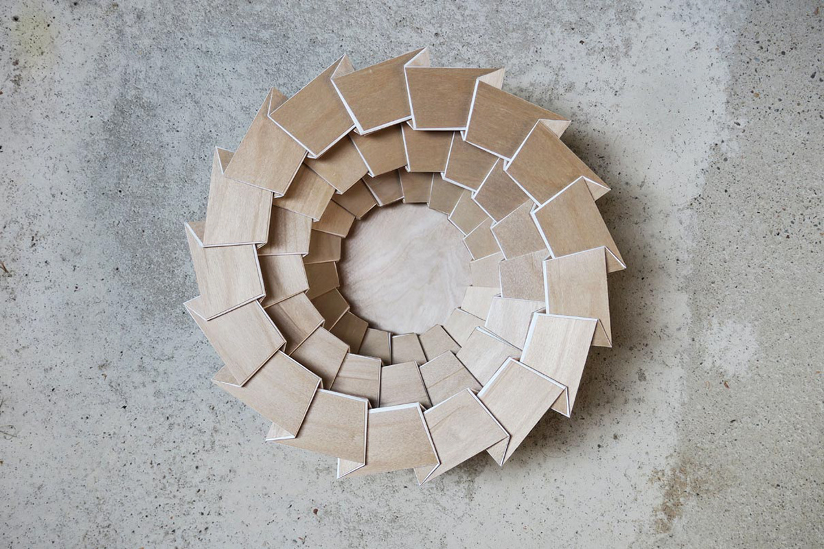 Foldable wooden bowl made of lasered wood with textile composite.