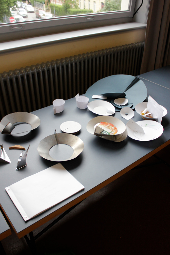 Student work with models and prototypes made of paper and metal.