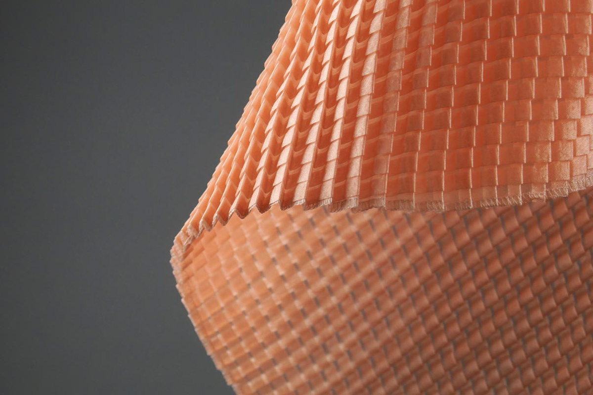 Graues synthetisches Textil maschinell plissiert anhand mit Hilfe von Spezialmaschinen und Hitze.